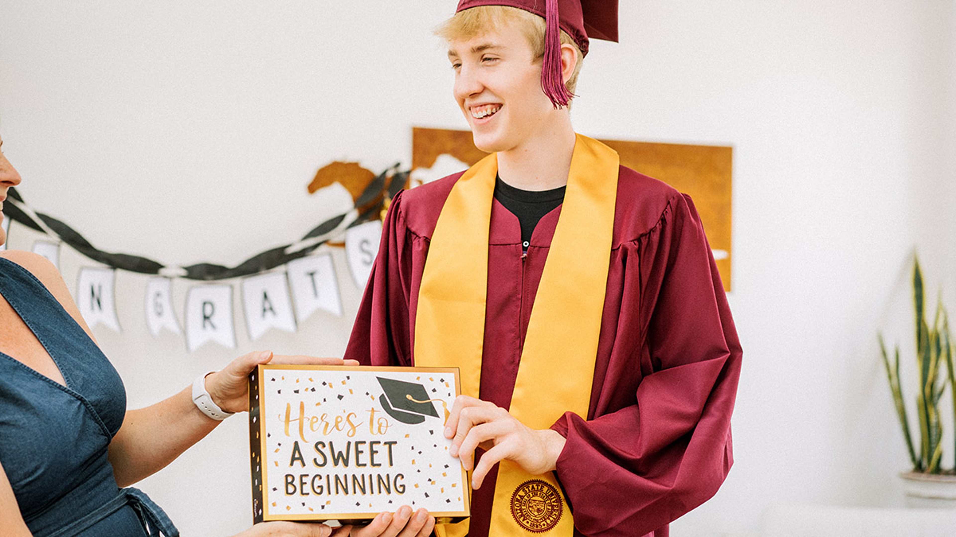 Article Cards Featured Image young man receiving a graduation gift from mother