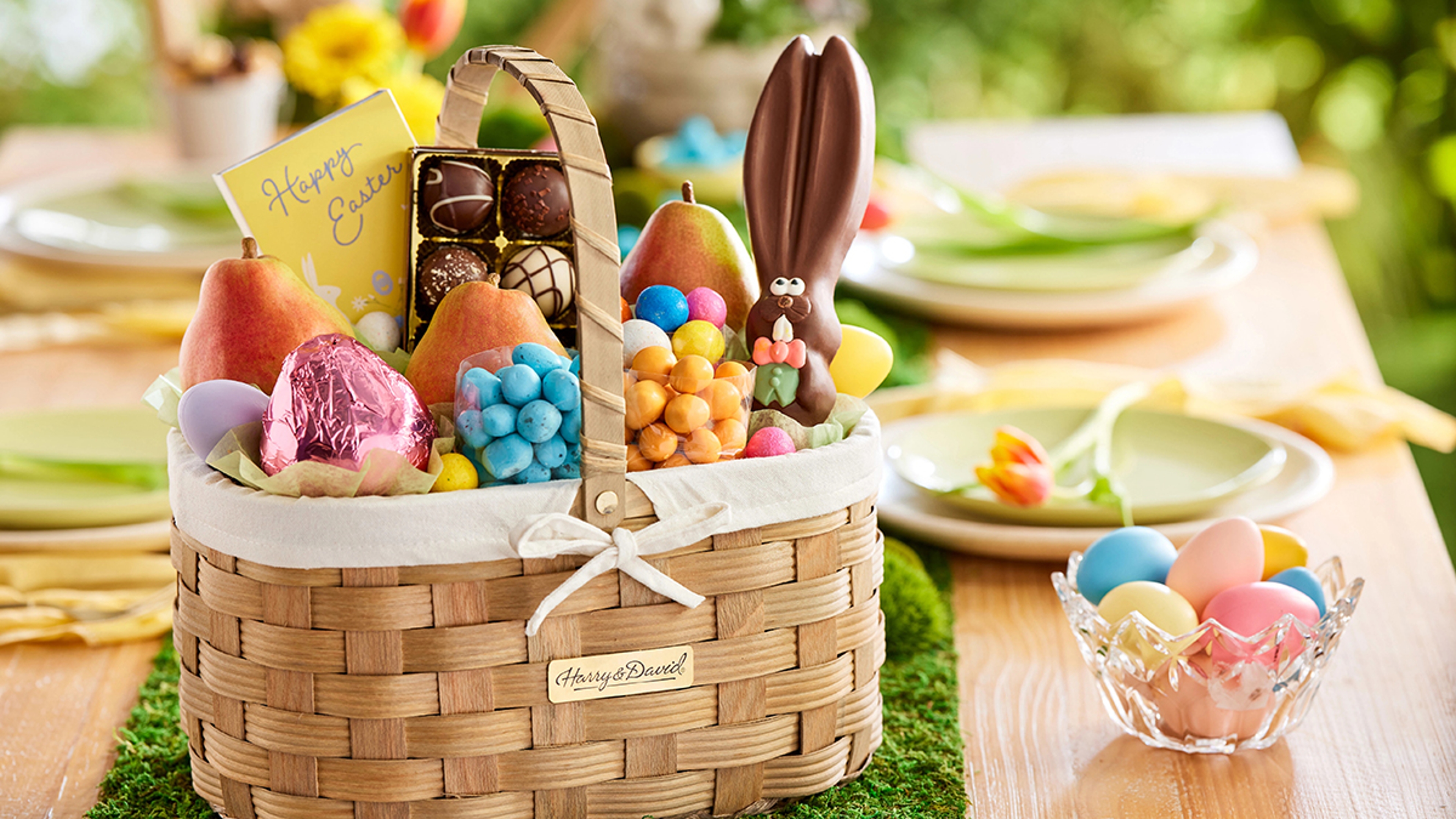 Easter basket full of chocolate, candy, fruit, and other snacks.