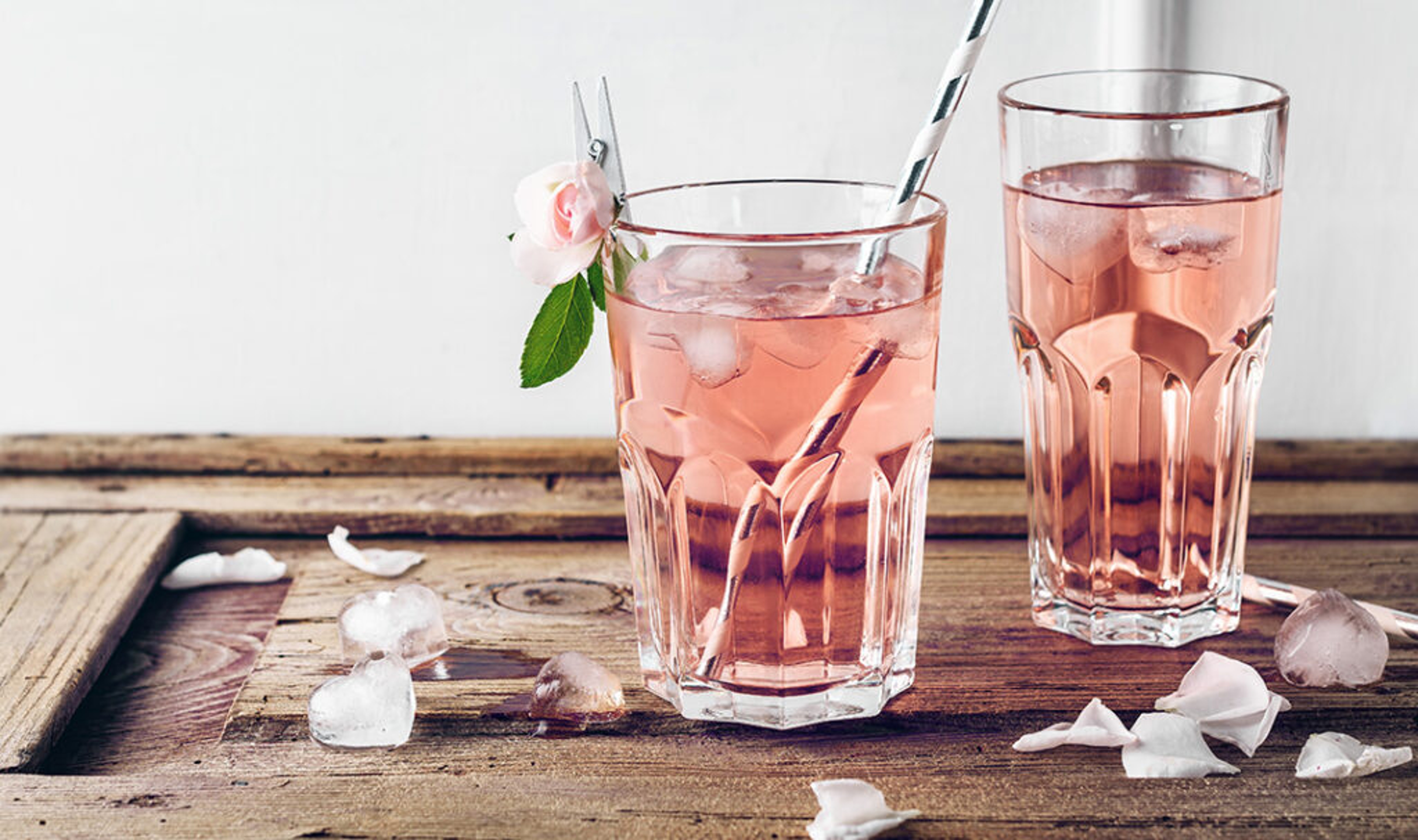 Two glasses of rosewater with ice cubes.