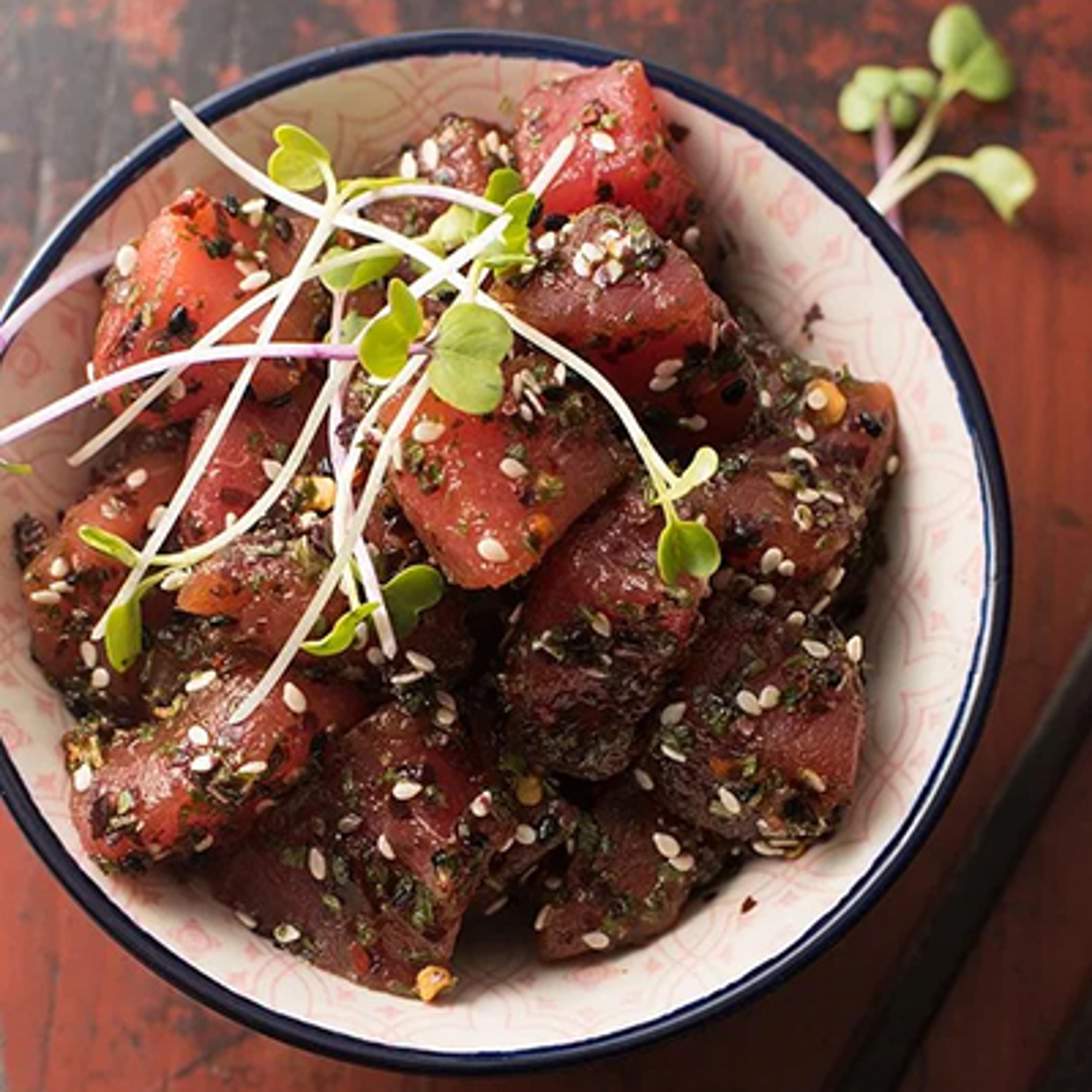 Summer fish recipes with a bowl of poke topped with greens.