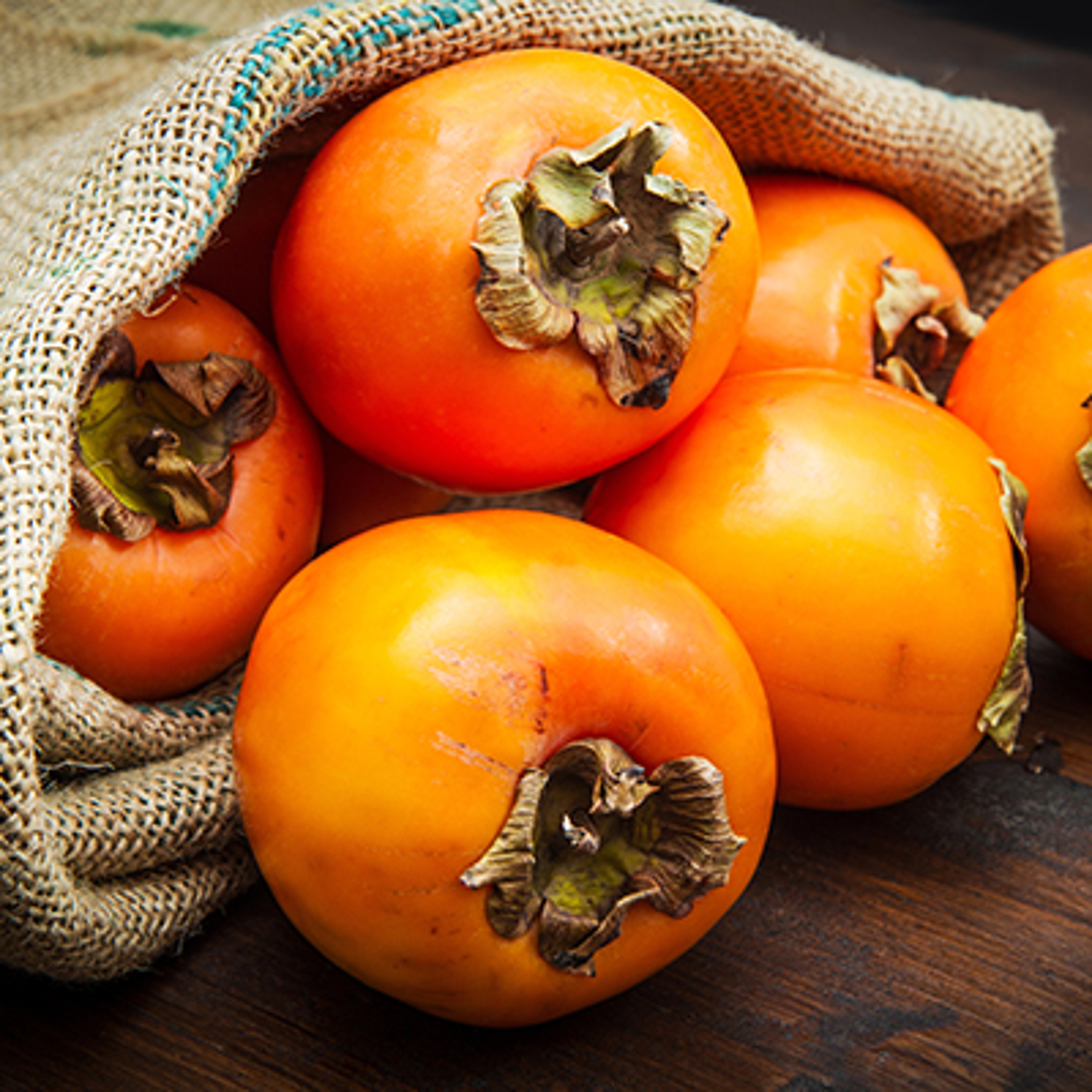 Delicious fresh persimmon fruit on wooden table