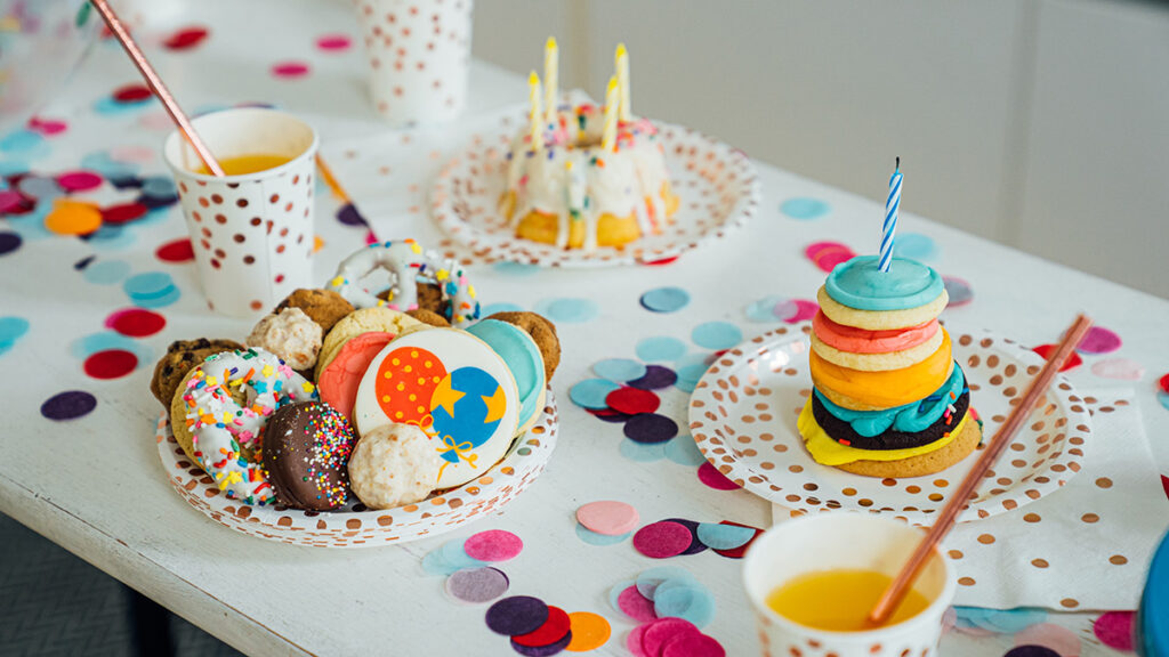 Birthday table laid with cookies and cake.