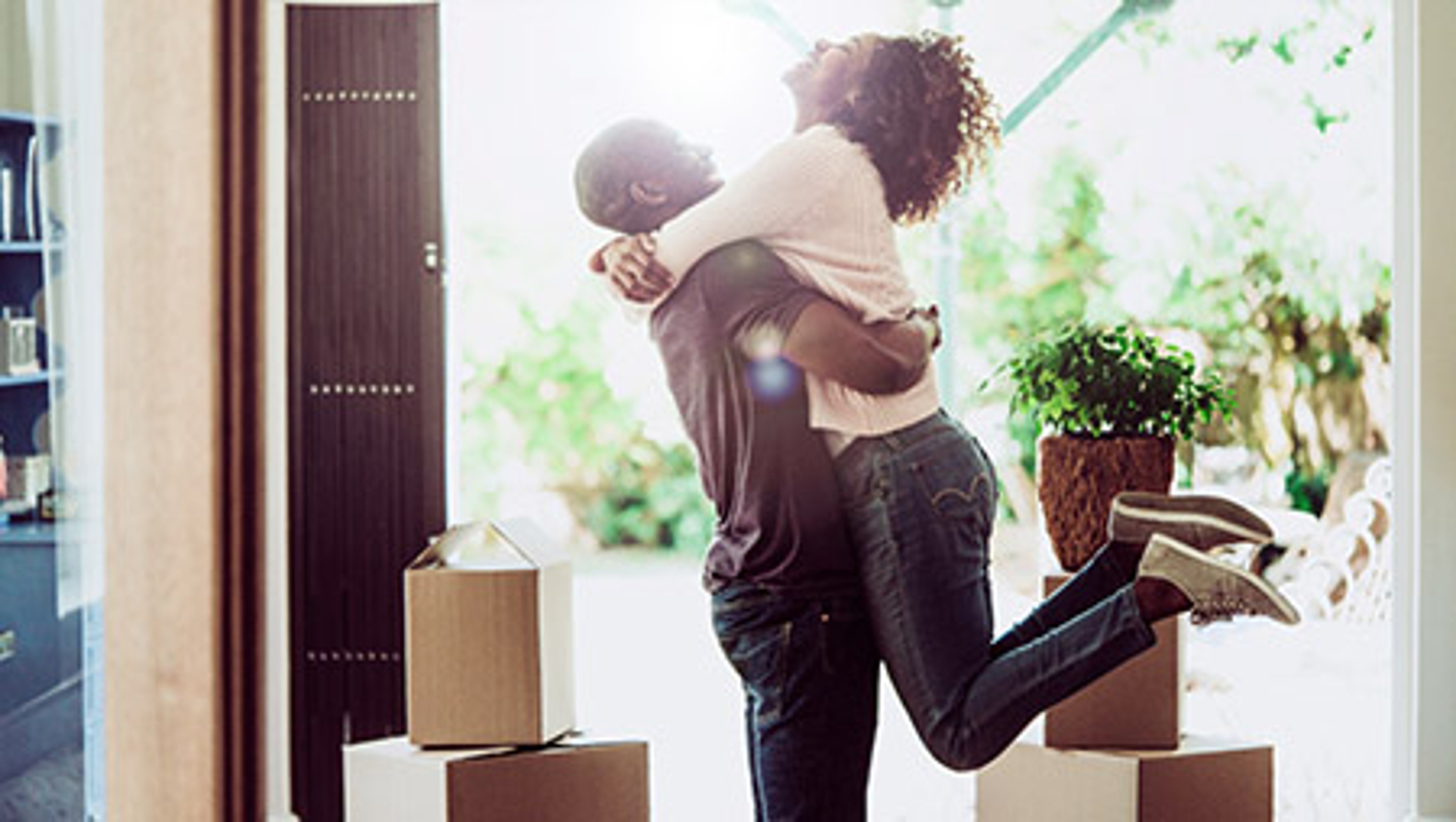 Happy man lifting woman in new house