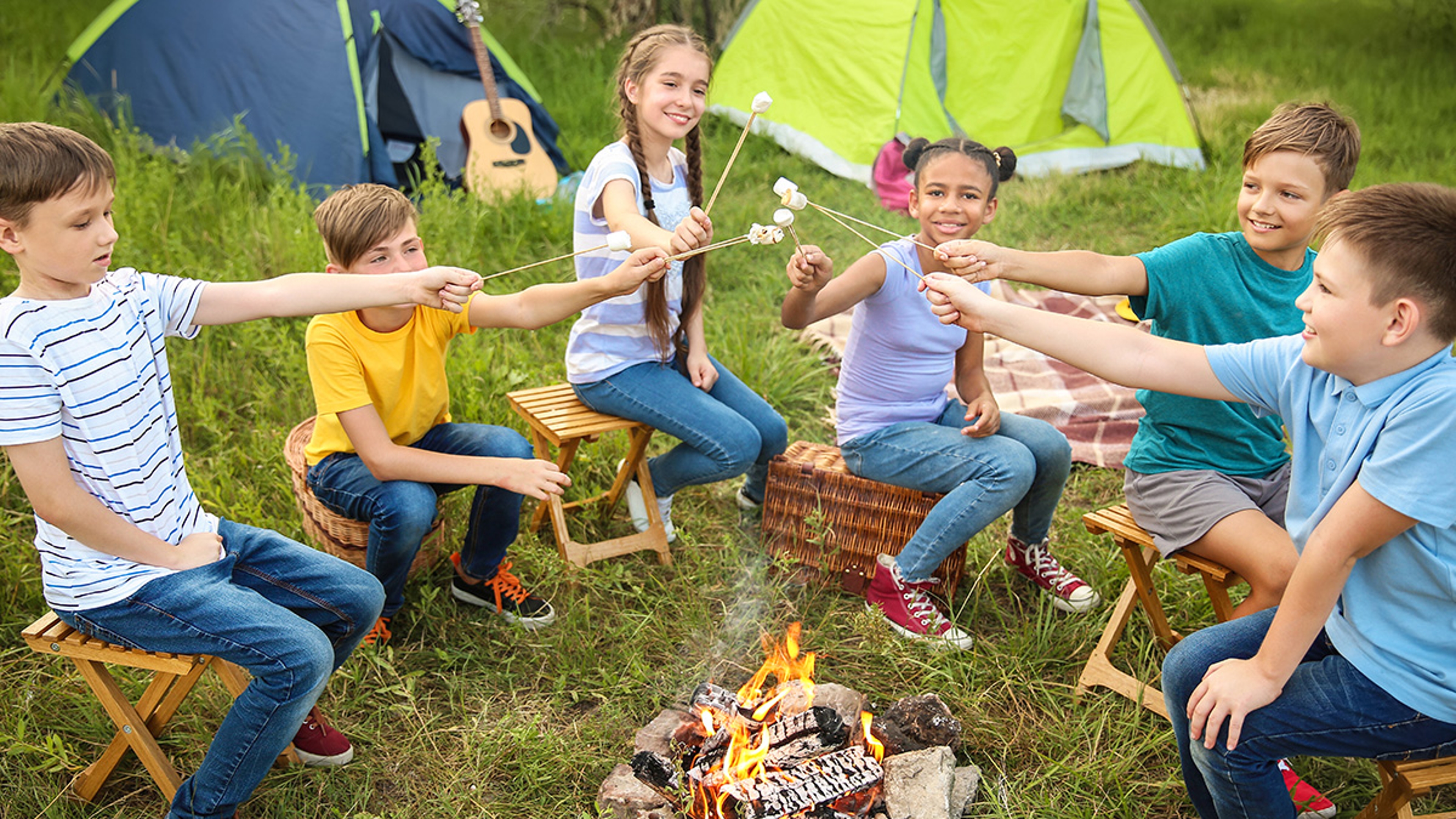 kids roasting marshmallows at a fall birthday party