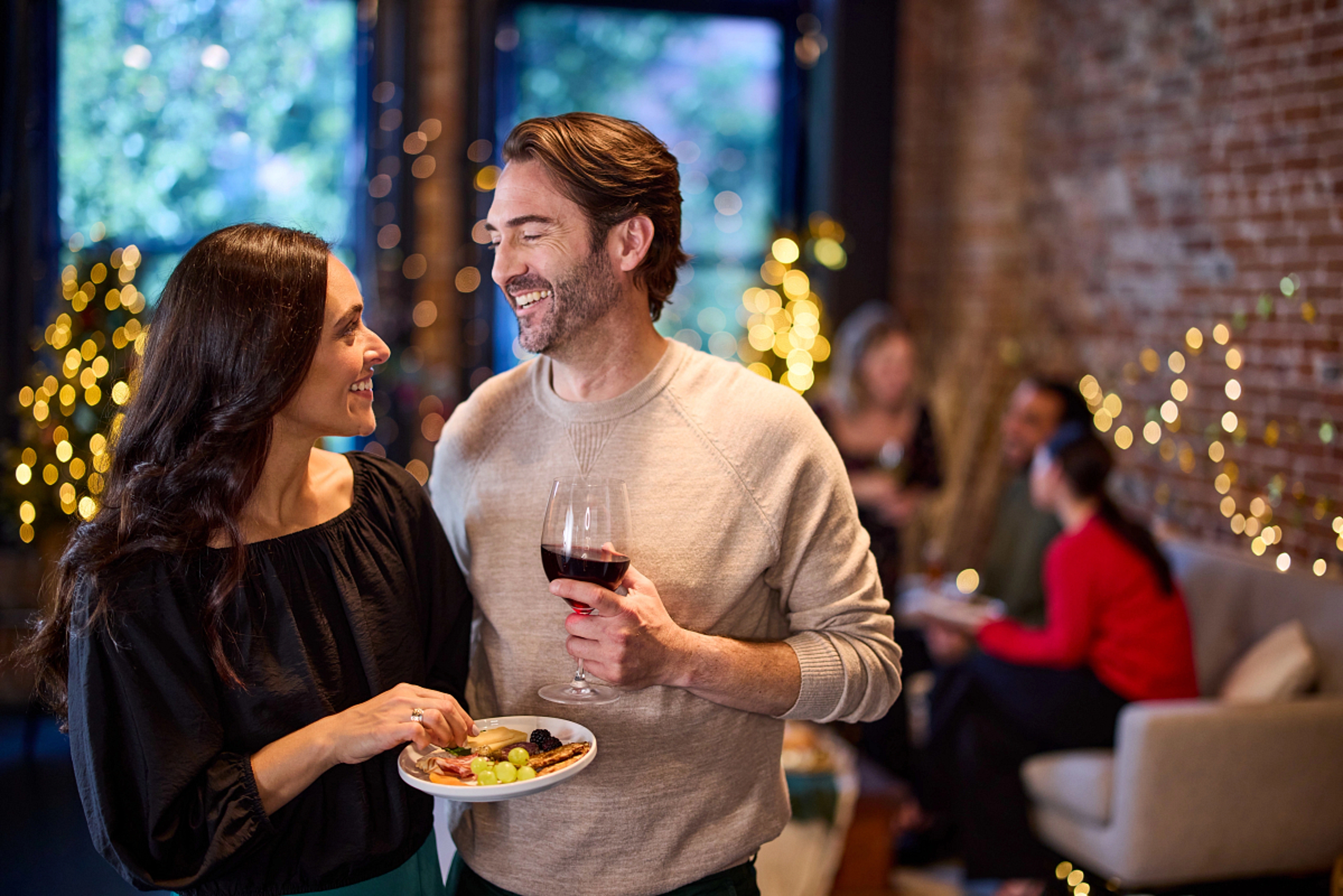 Couple talking at a holiday dinner party.