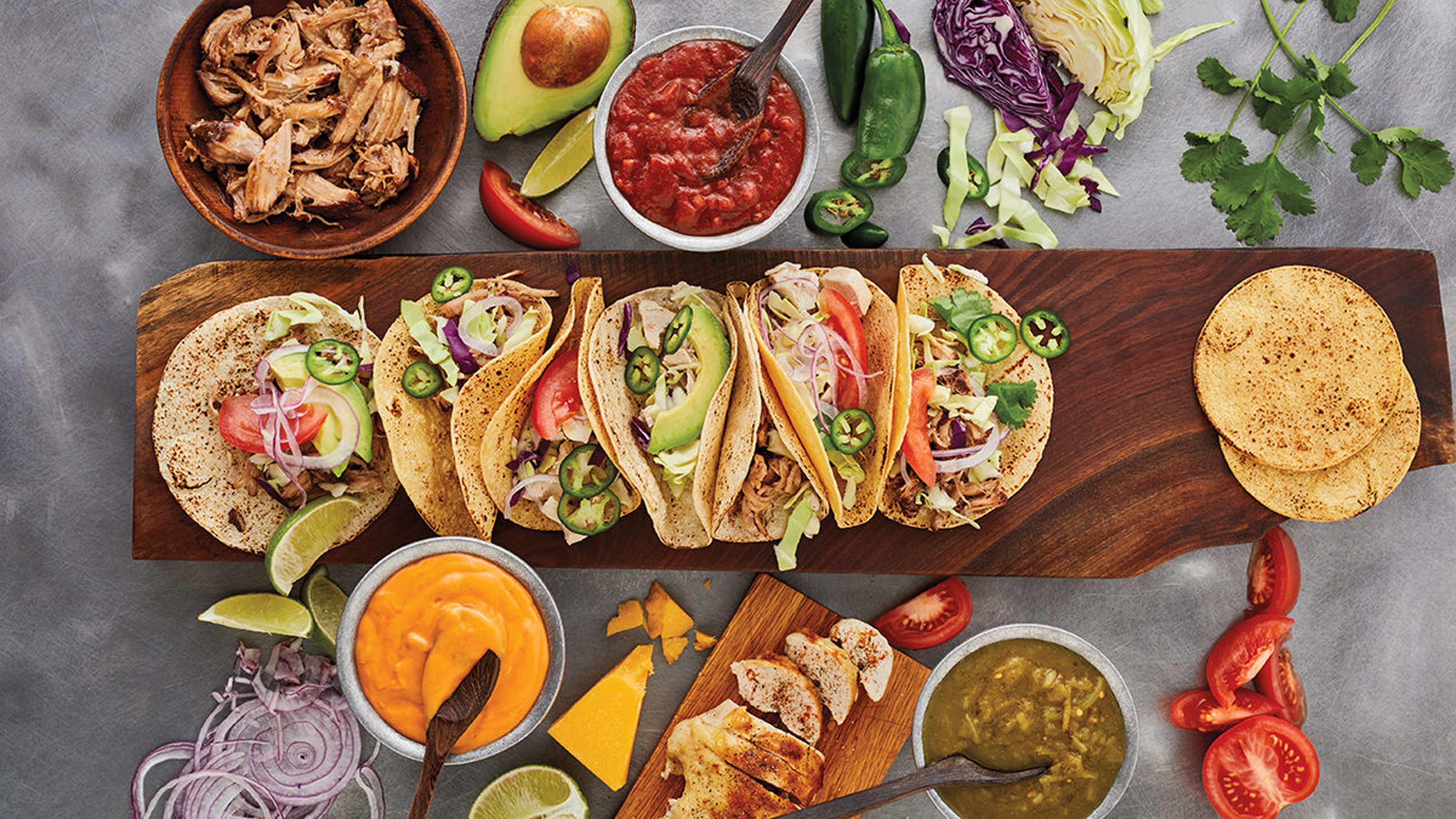 Spread of tacos with salsa and cheese dip.