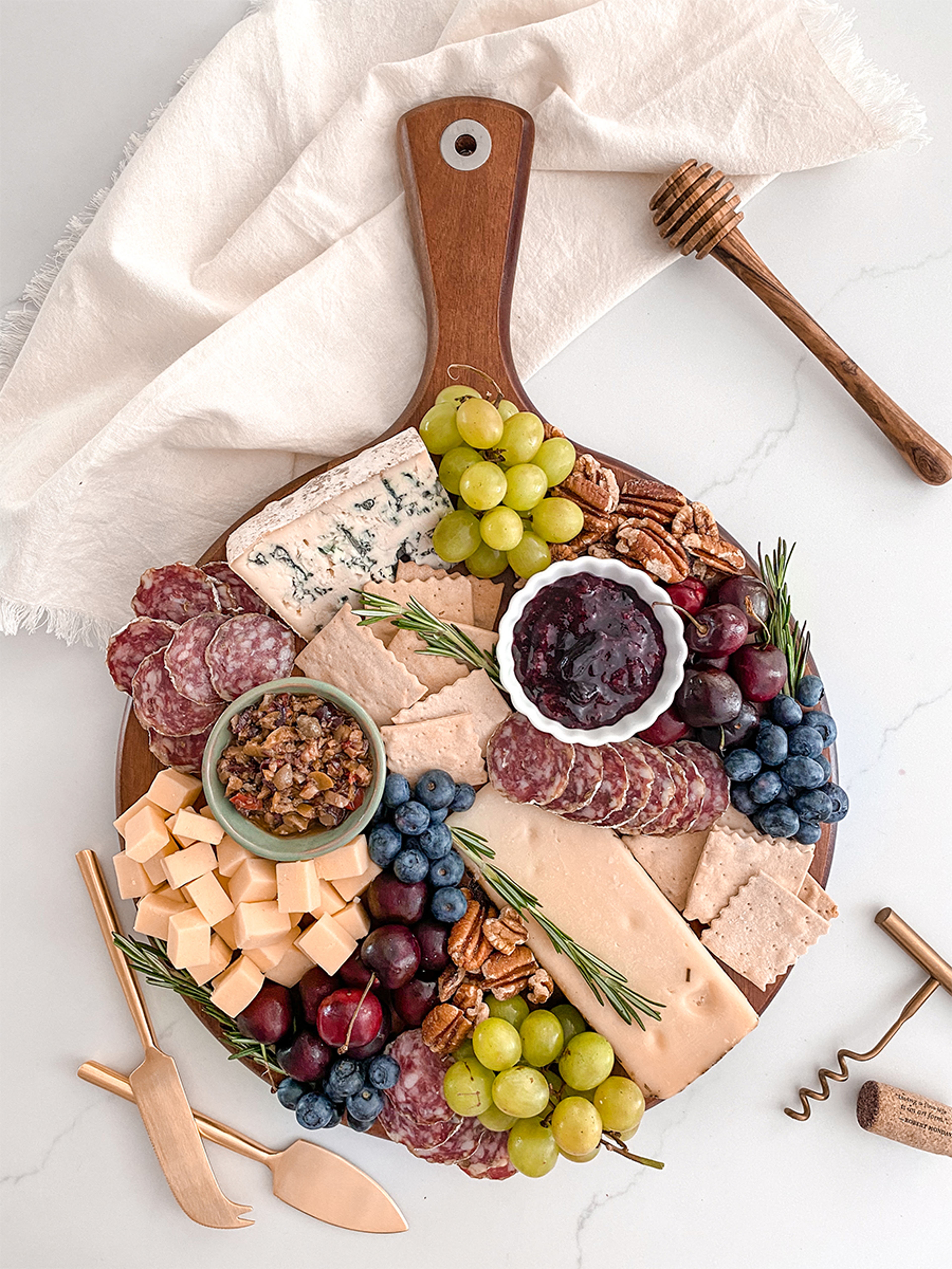 How to create a charcuterie board with cheese, nuts, fruit, and other snacks.