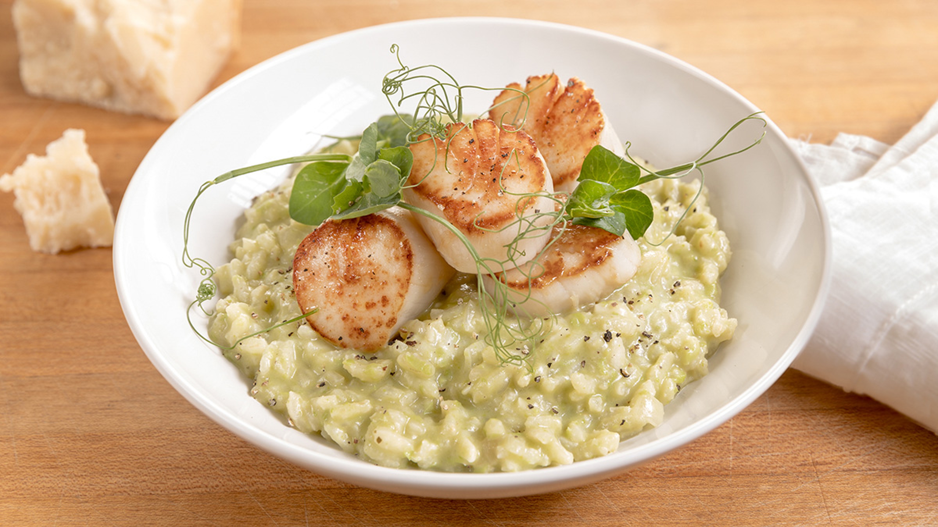 Scallops and pea risotto in a bowl.