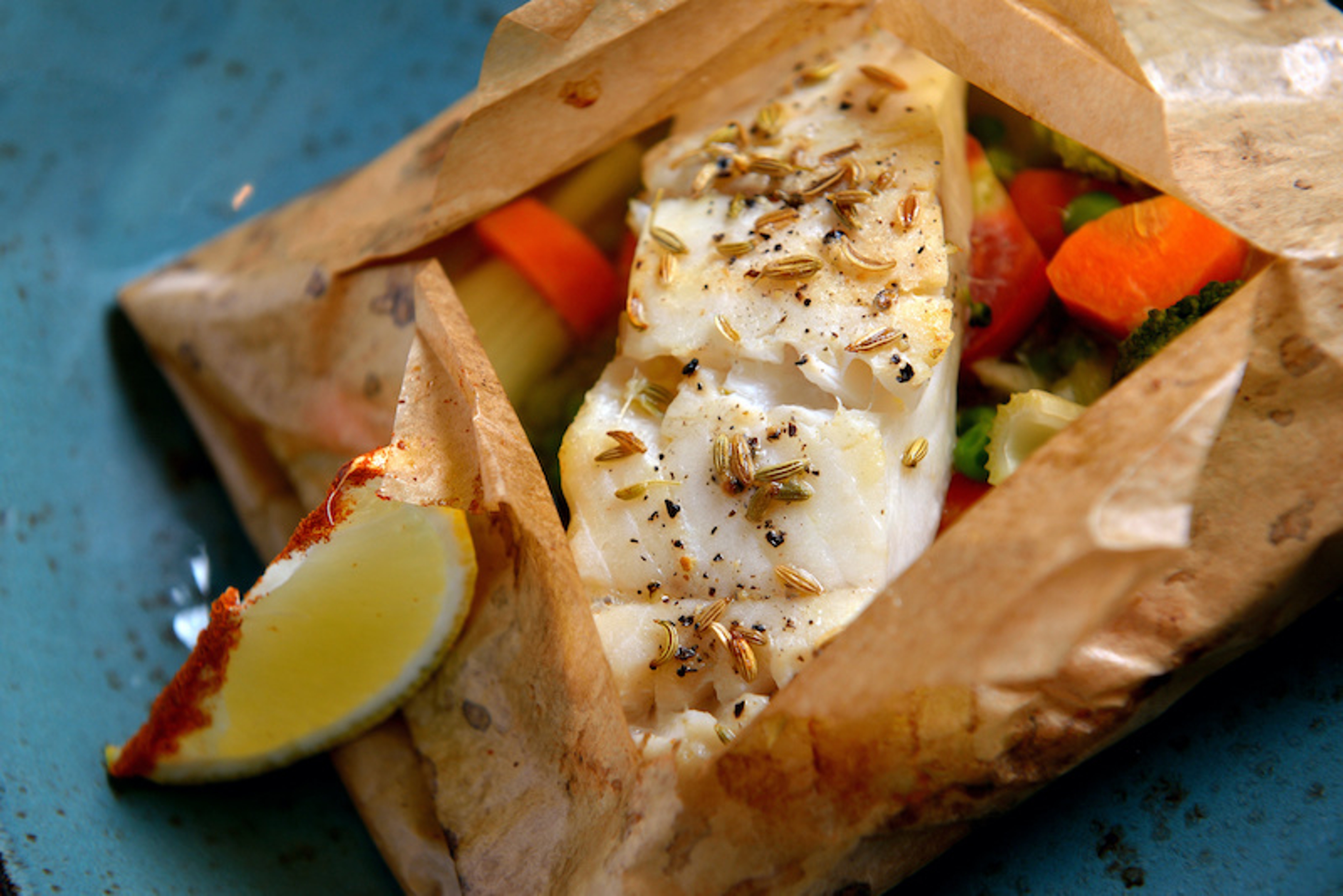White fish fillet baked in paper, parchment with vegetables