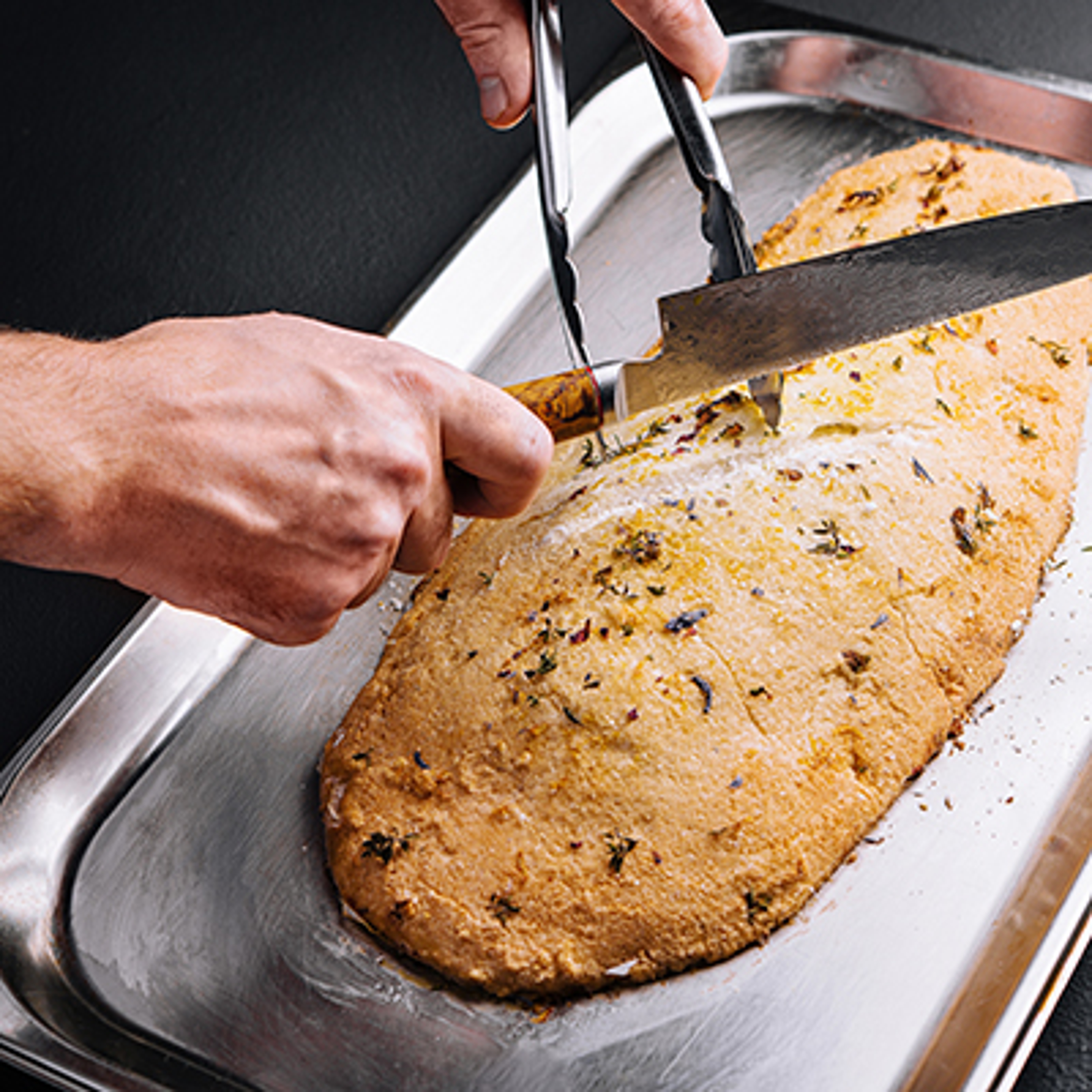 Baked fish, stuffed with herbs, in salt crust chef cuts