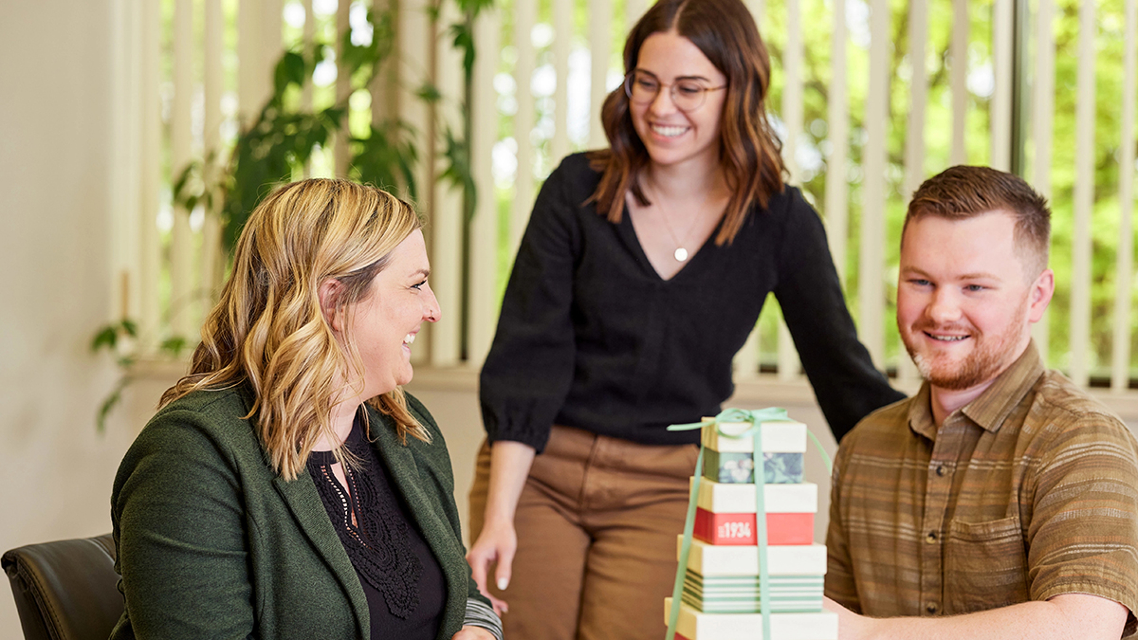 Employee appreciation ideas with several employees opening a gift box.