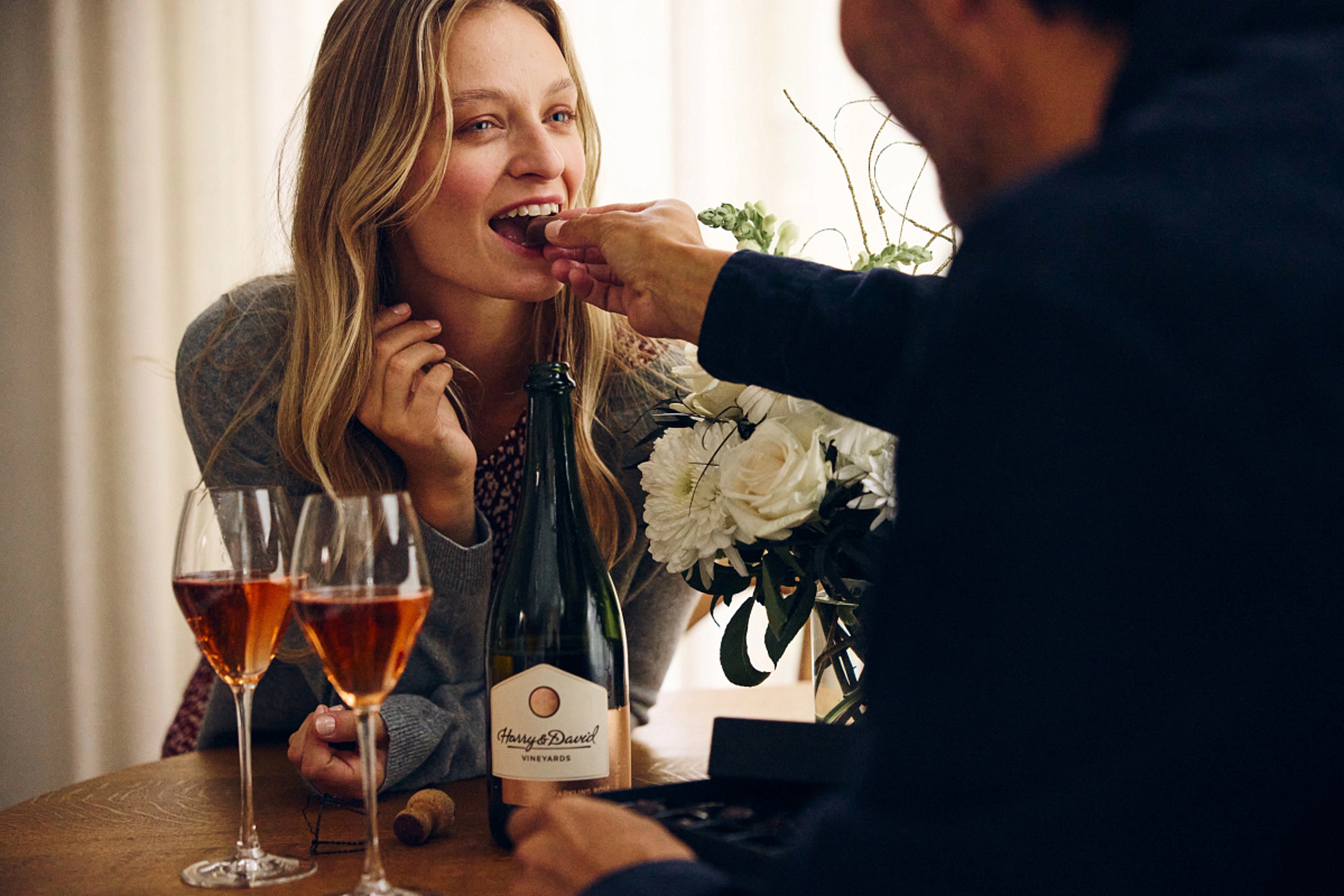 Couple sharing wine and chocolate for a November birthday celebration.