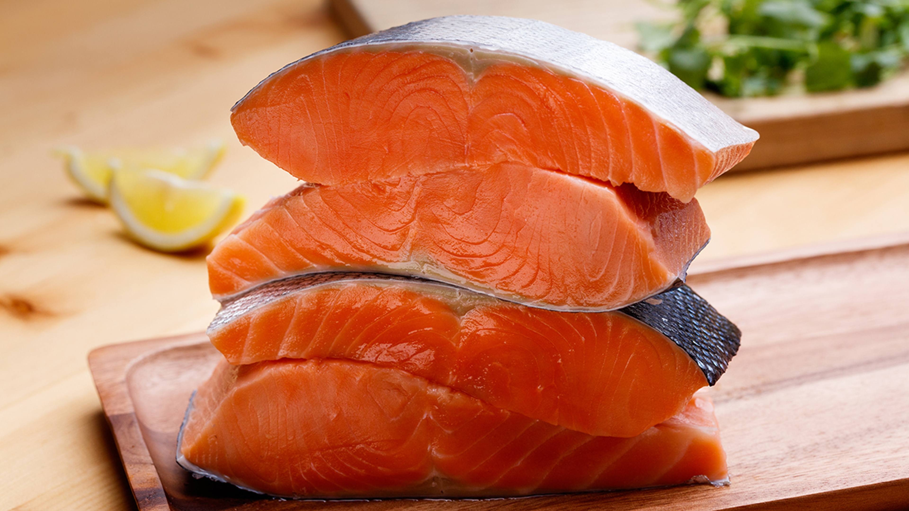 Stacks of Alaskan King Salmon fillets on a cutting board.