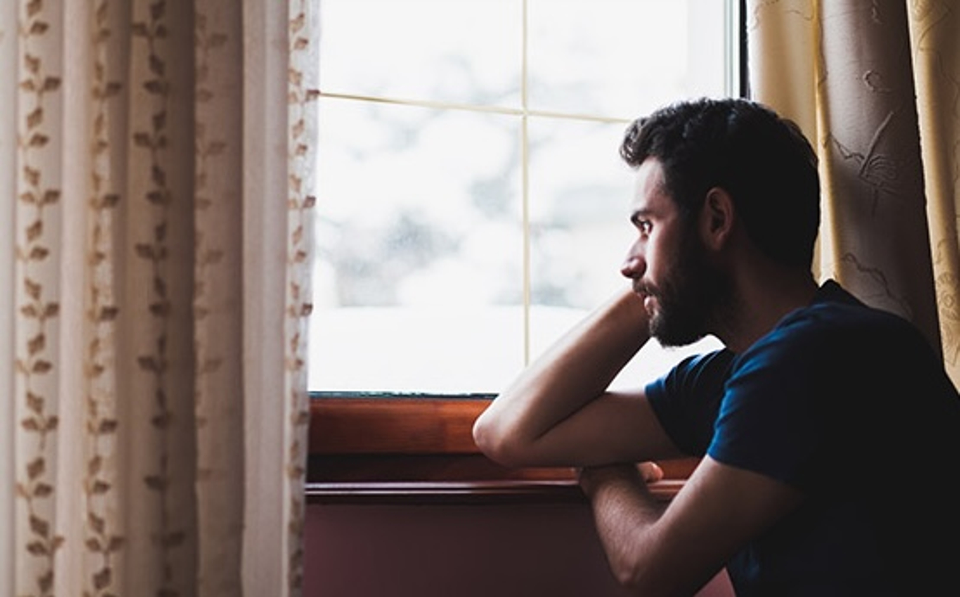 winter blues man looking out window