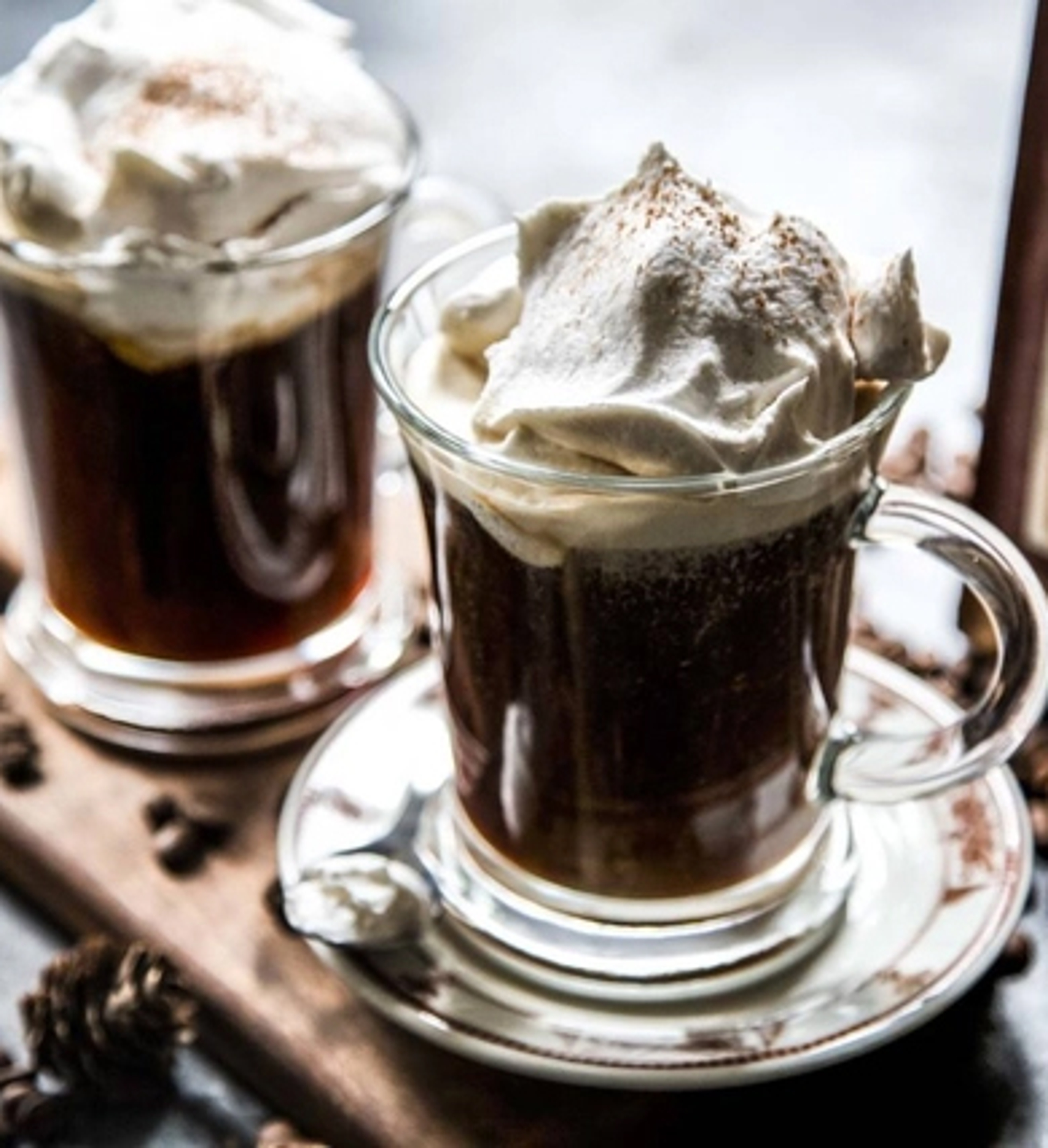 Two Irish coffees topped with whipped cream