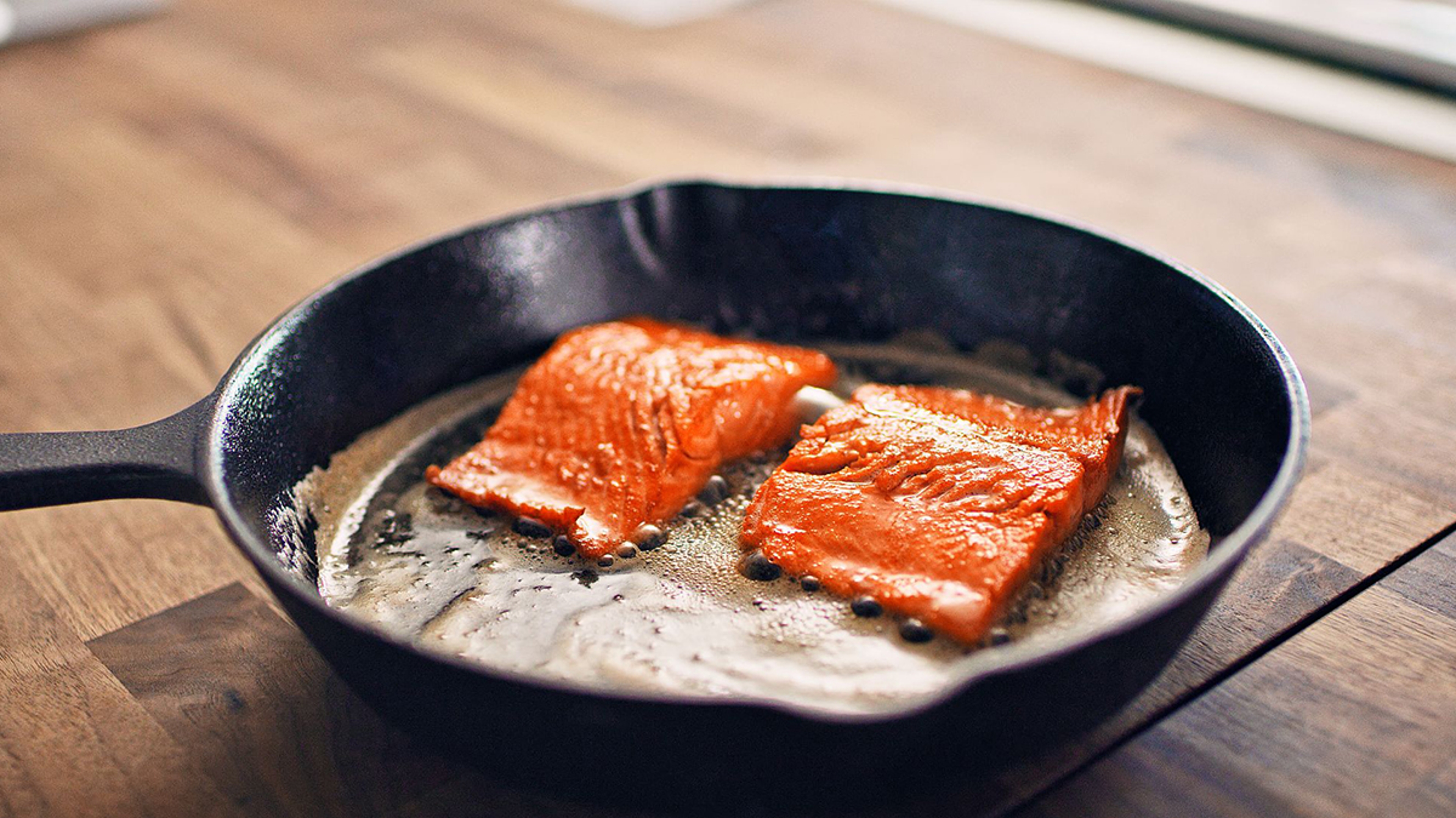 Copper River sockeye salmon filets in cast iron pan.