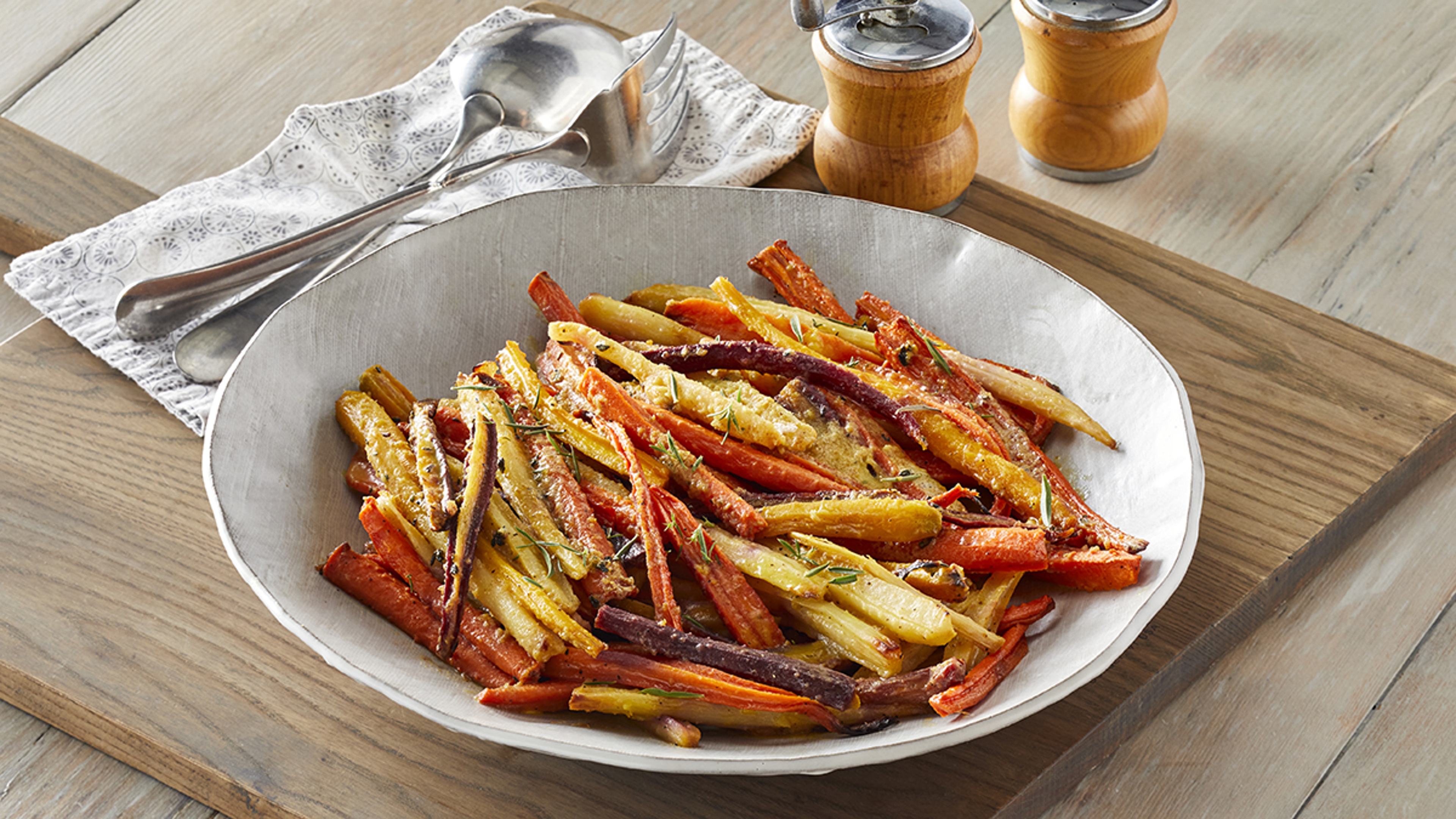 Holiday prepared meals with a bowl of cooked rainbow carrots with herbs.