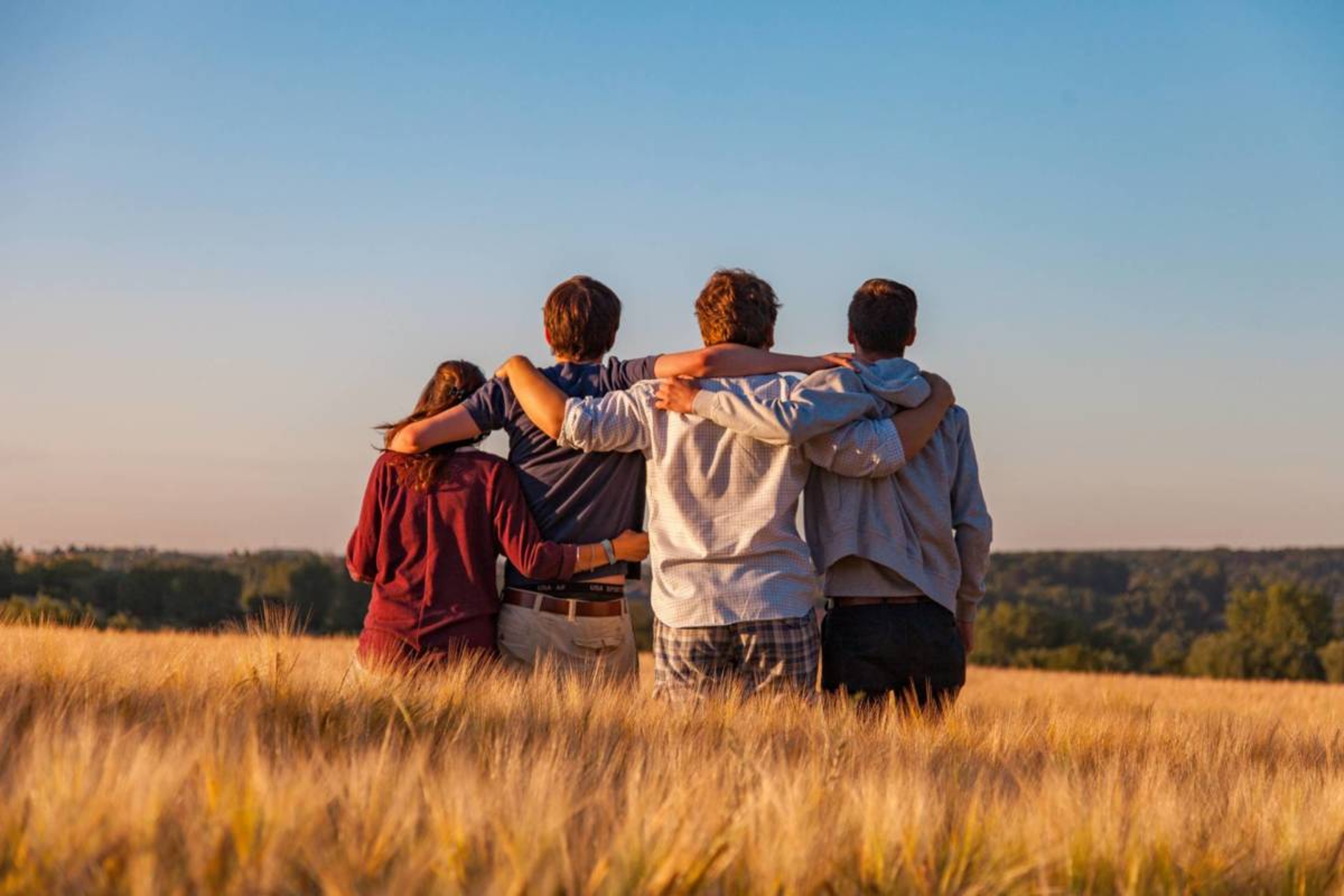 Group of people standing in a grass field