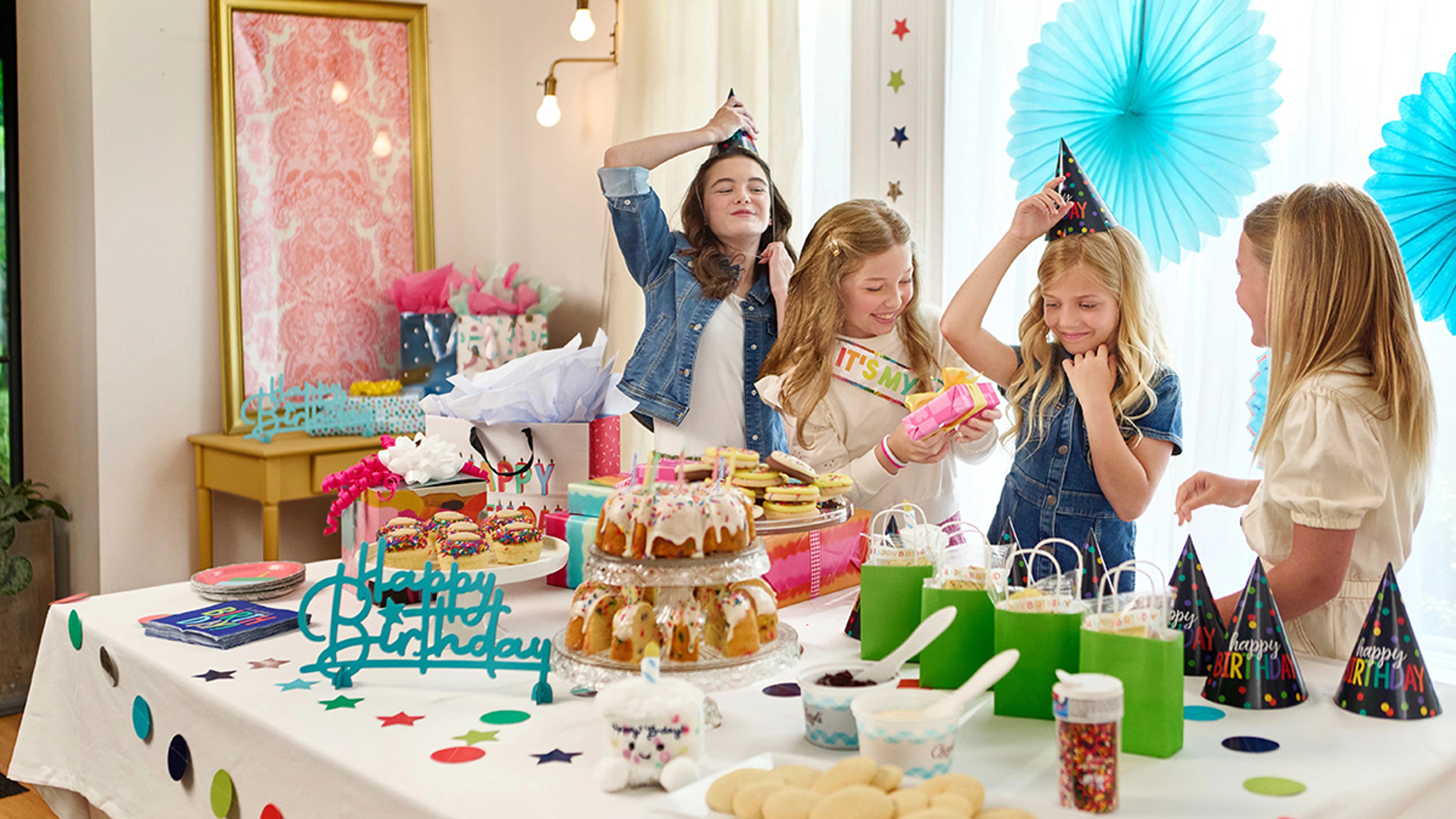 Group of young girls putting on party hats.