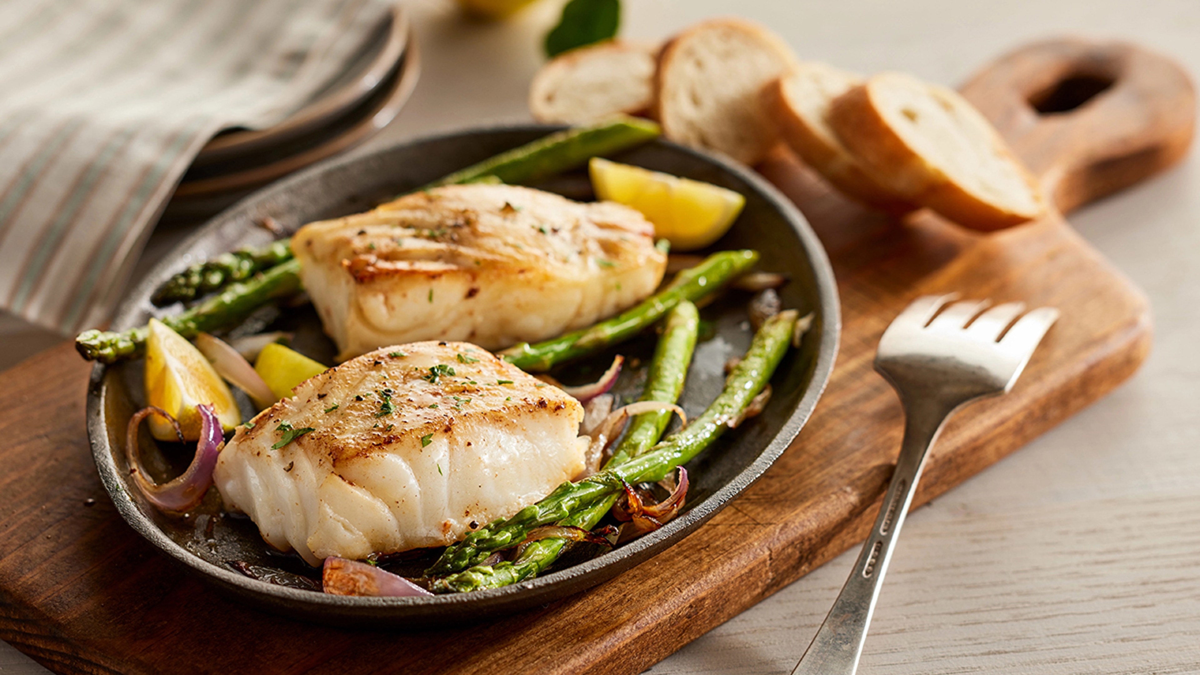 Chilean sea bass on a plate with vegetables.