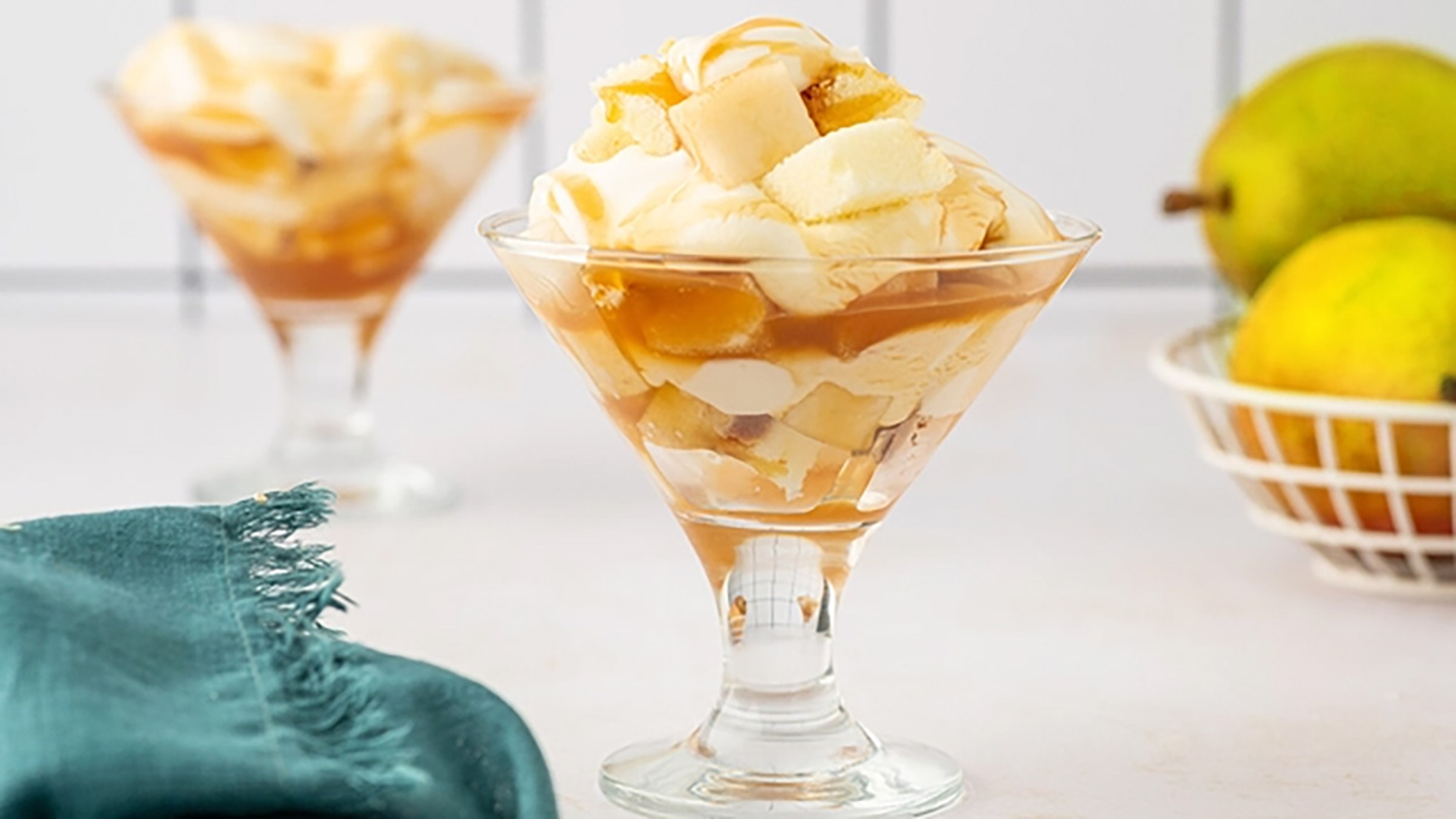 Cheesecake trifle with sliced pears and caramel sauce.
