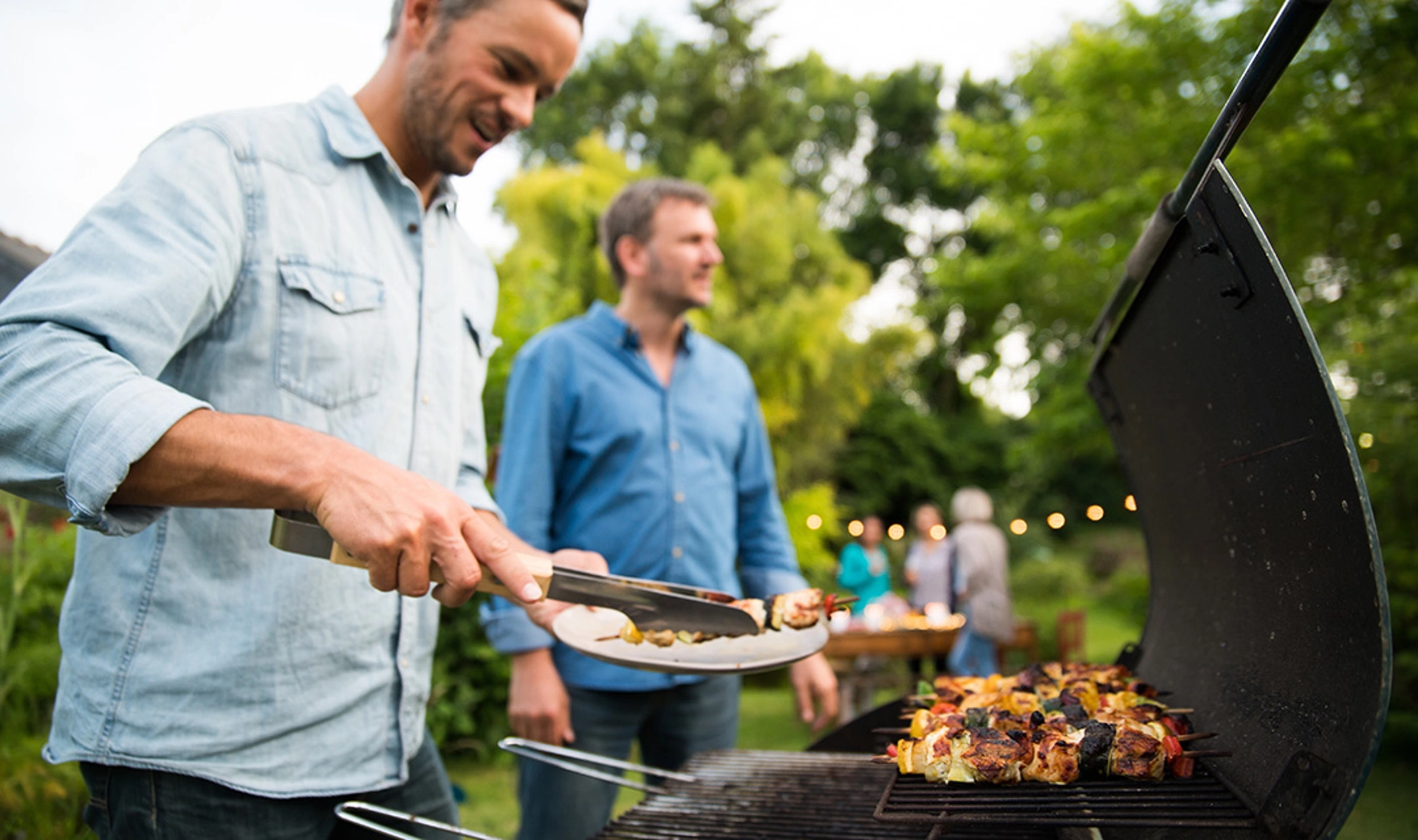 Two men grilling outside.
