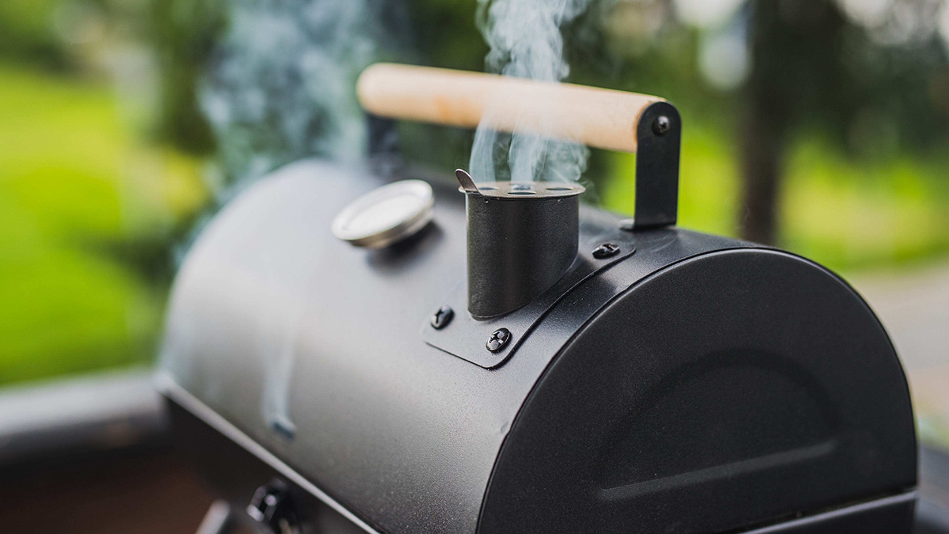 Food hobbies with a smoker with the lid closed and smoke coming out.