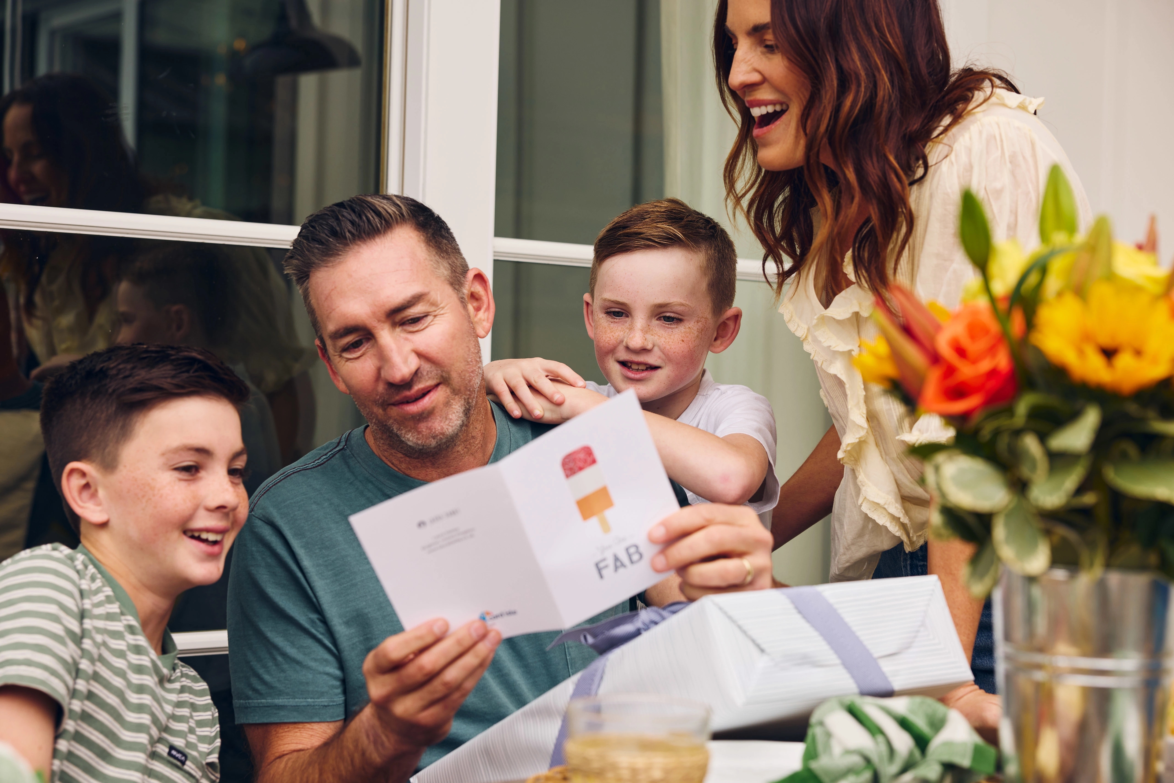 Article Cards Featured Image fathers day messages dad reading greeting card with kids