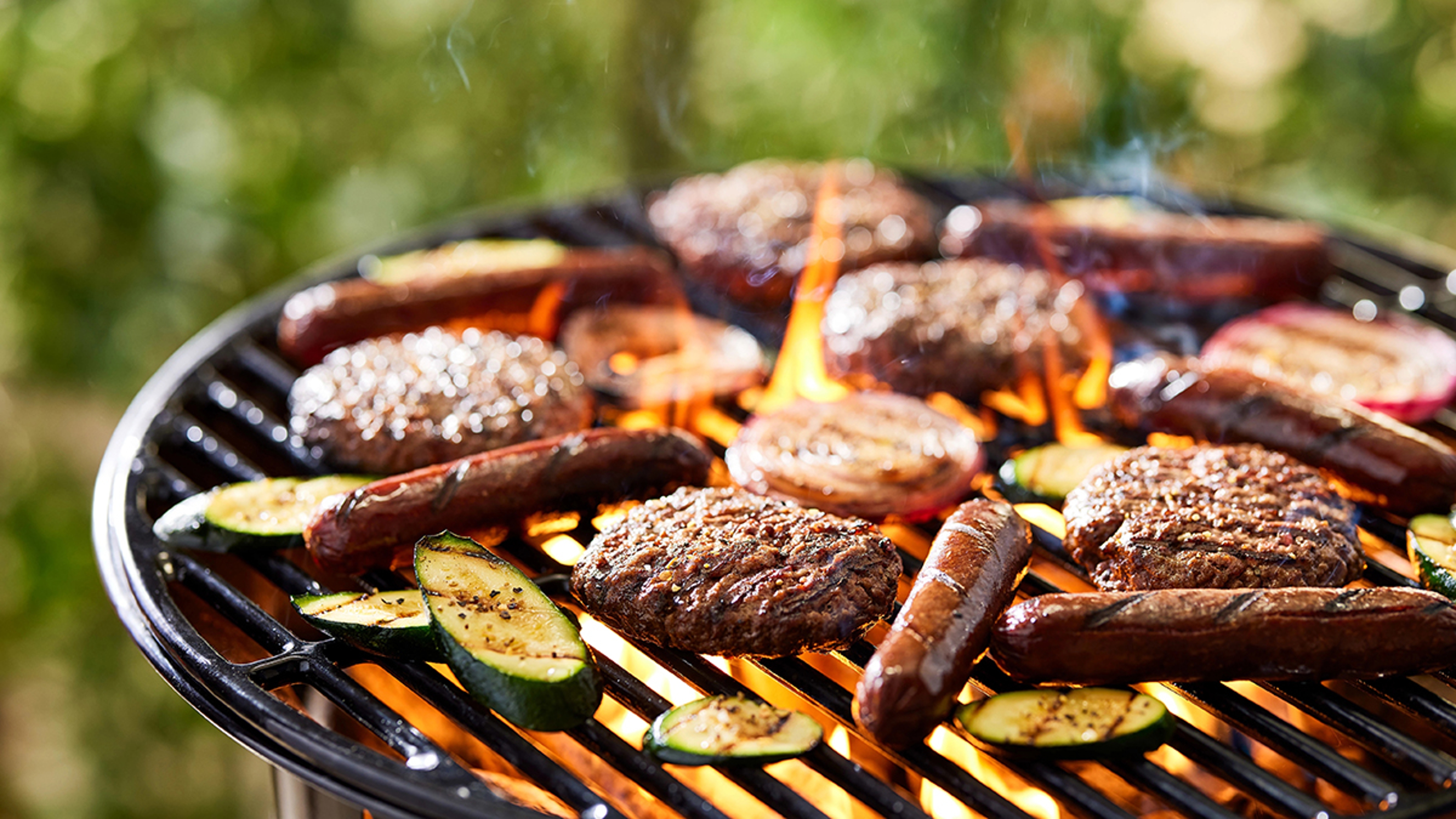 Bison hot dogs and burgers on a grill.