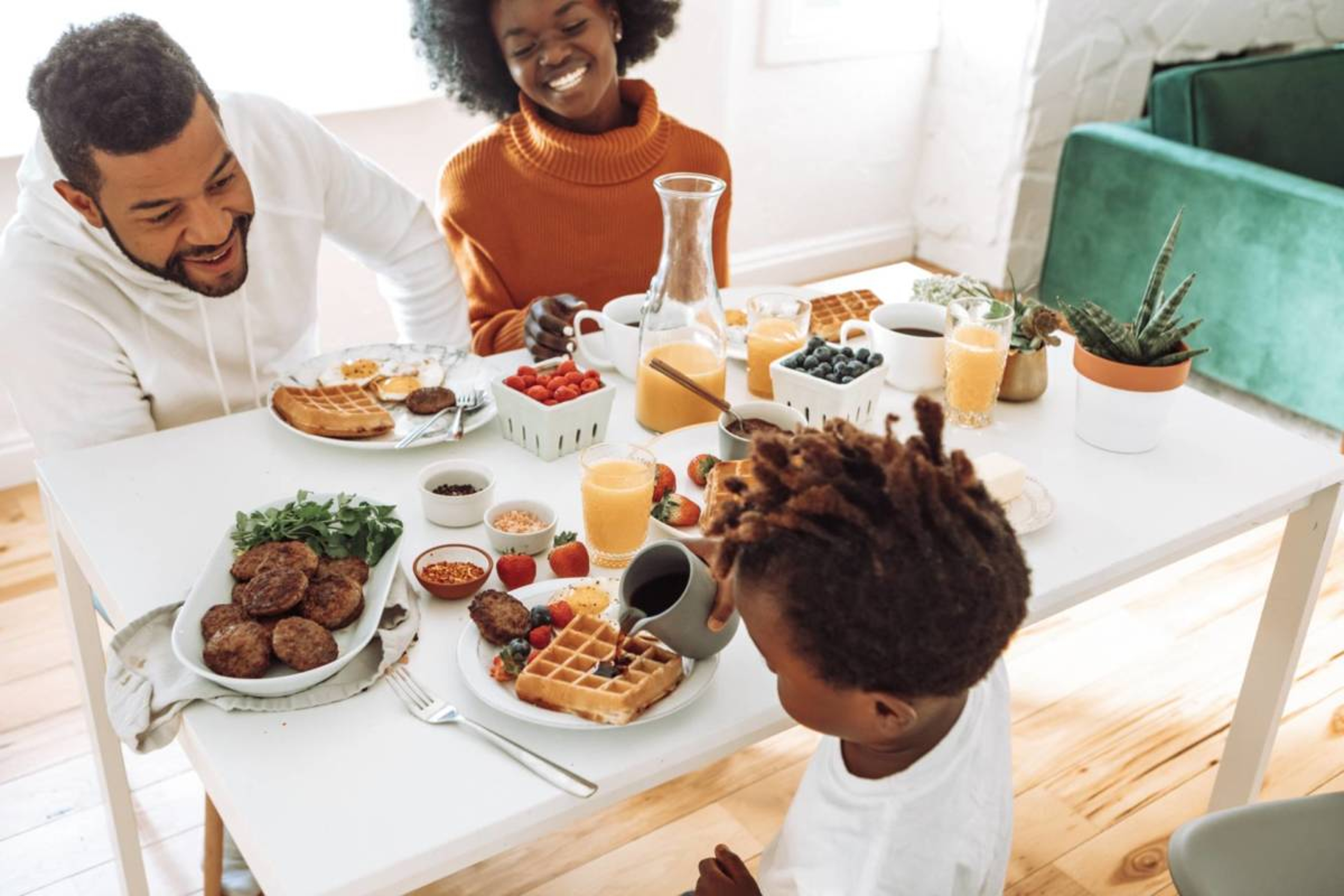 Family sitting around dining room table enjoying breakfast meal