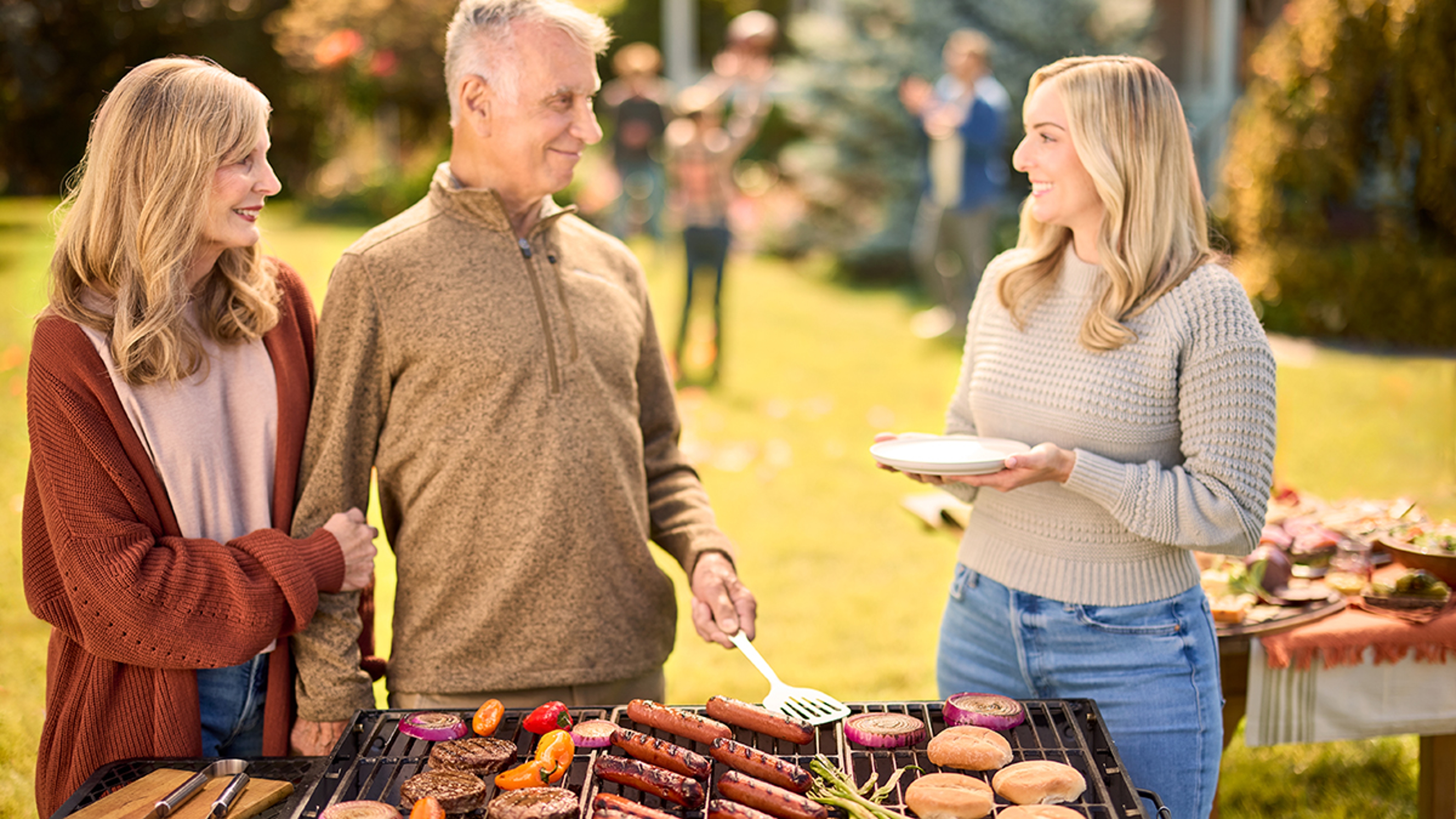 Family grilling outside with tailgating essentials