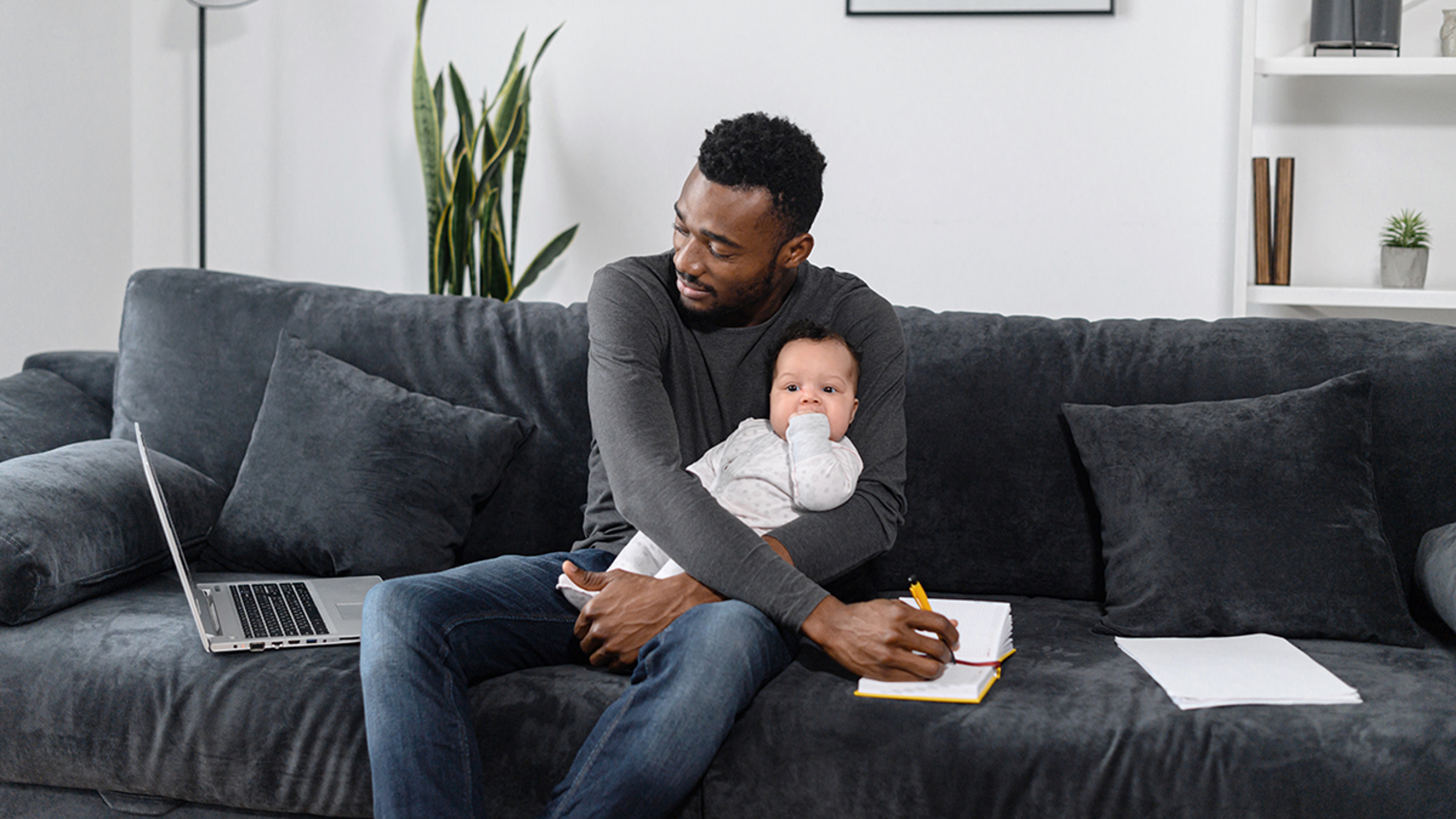 daddy brain man working on computer while holding baby