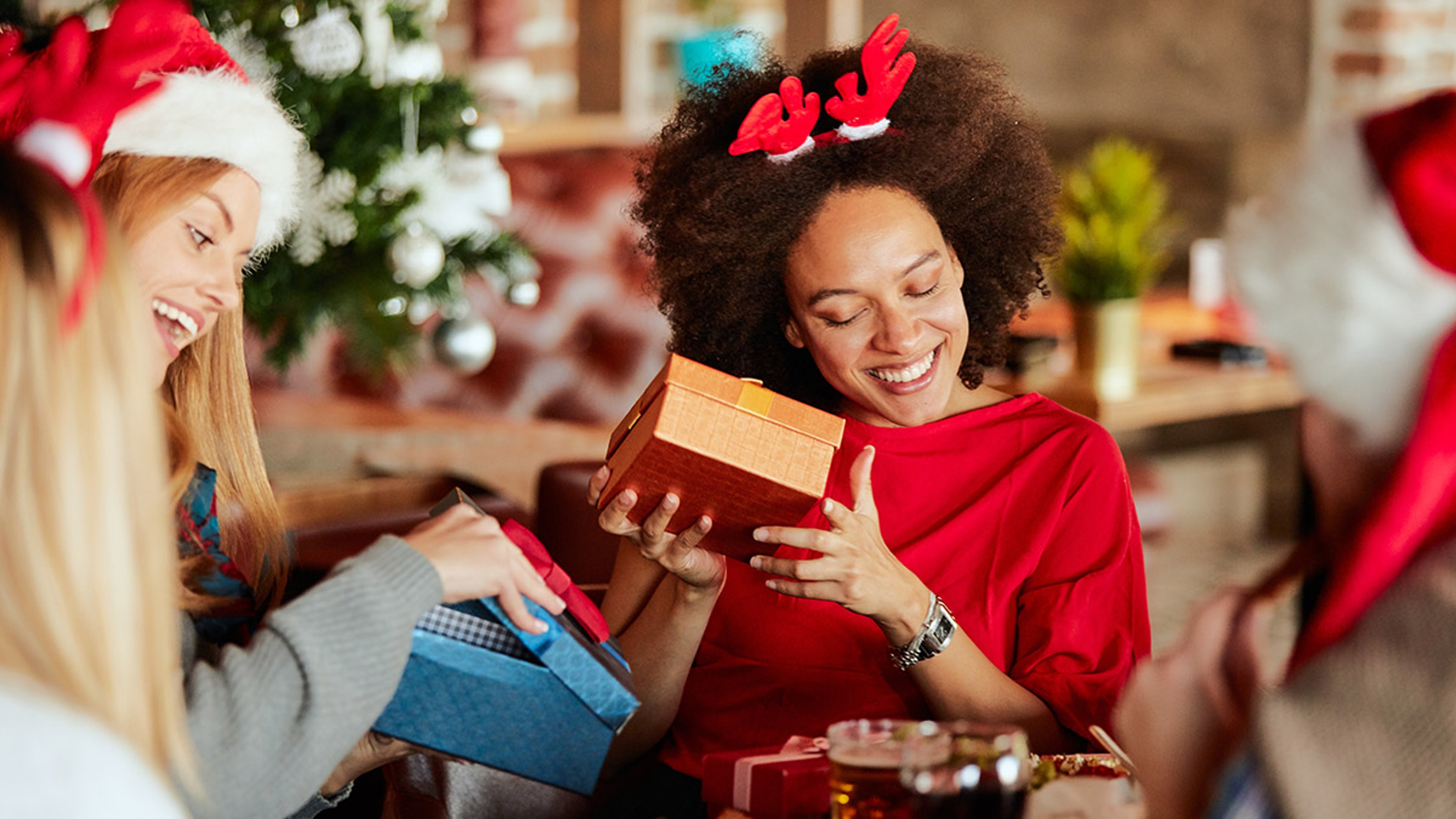 Two women opening Christmas gifts.