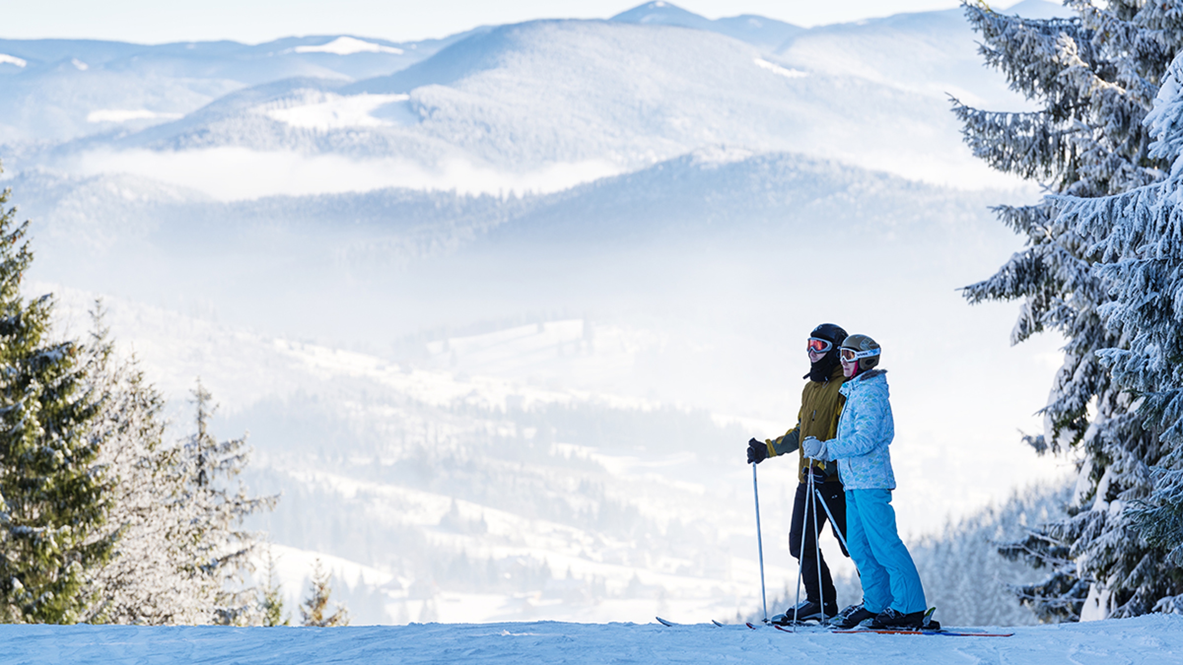 Couple of skiers on the background of beautiful mountains panorama