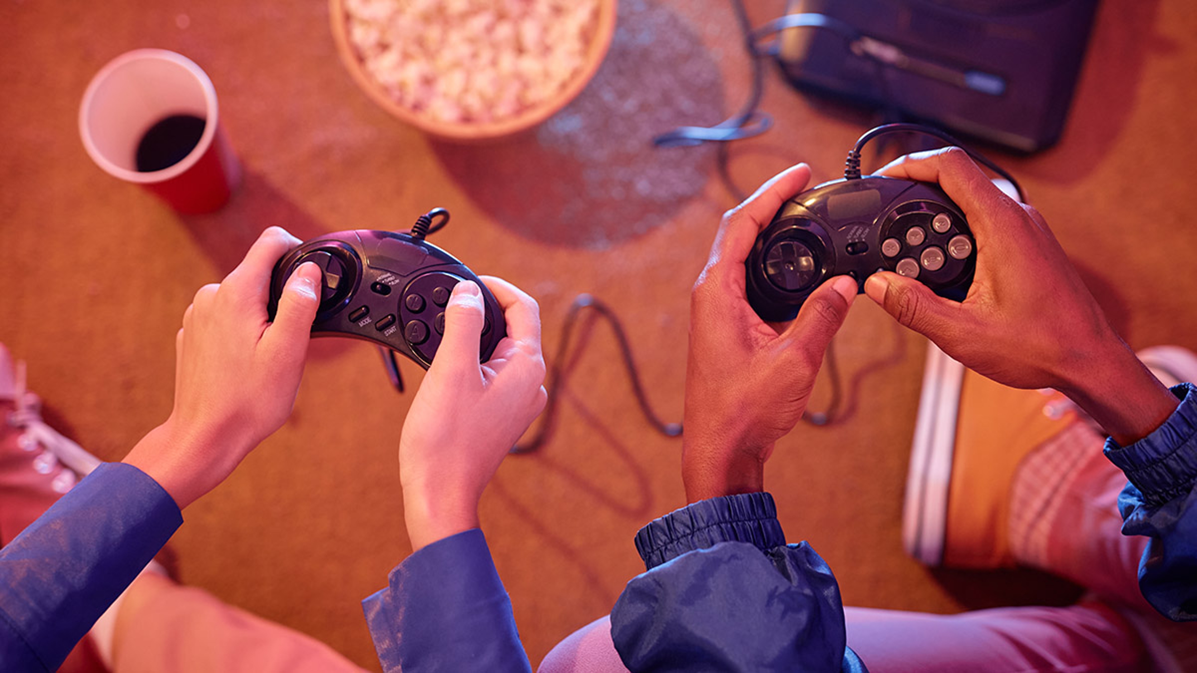 Two young people playing retro video game and holding controllers