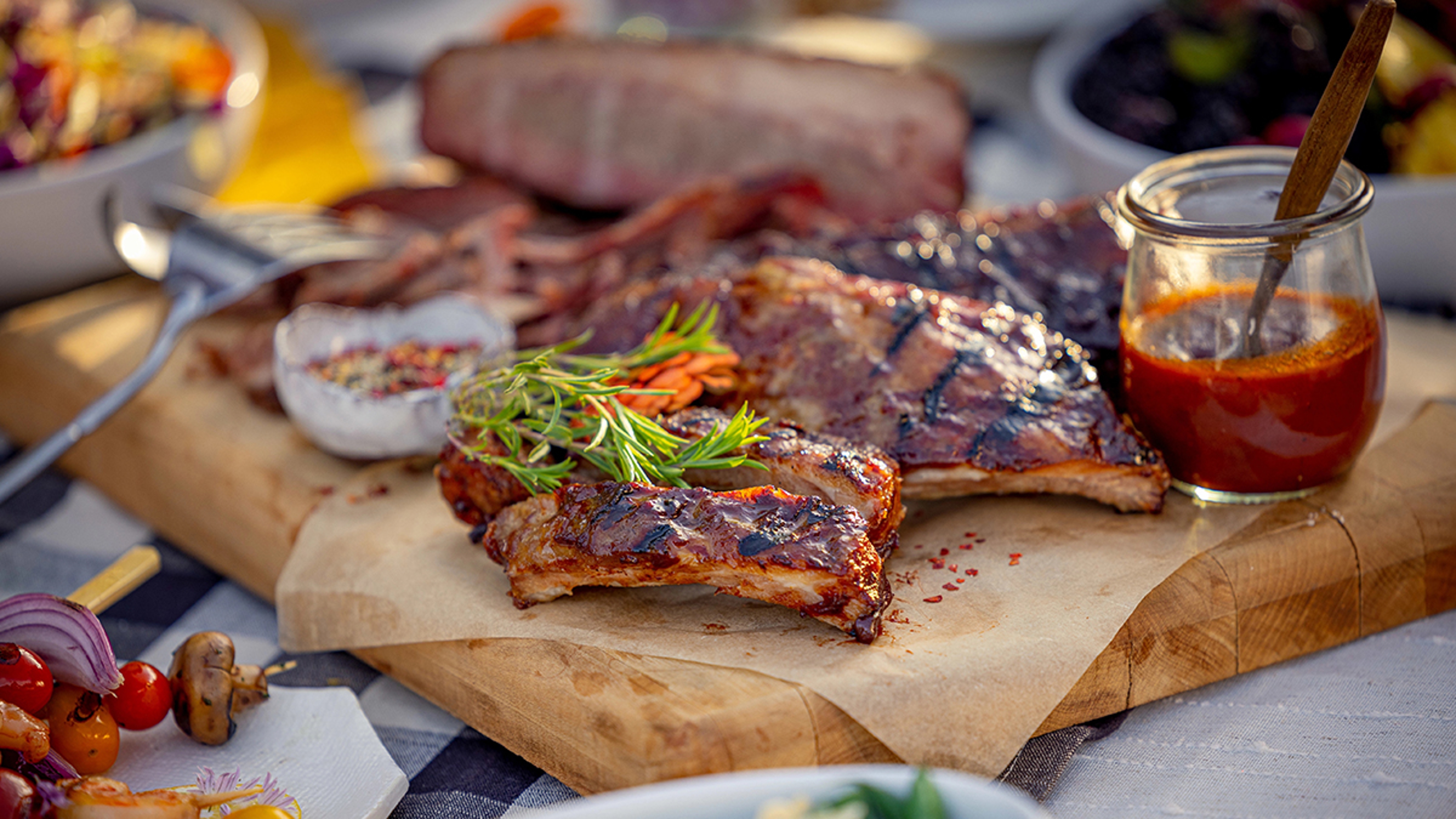 difference between grilling, barbecue, and smoking barbecue ribs on a table.