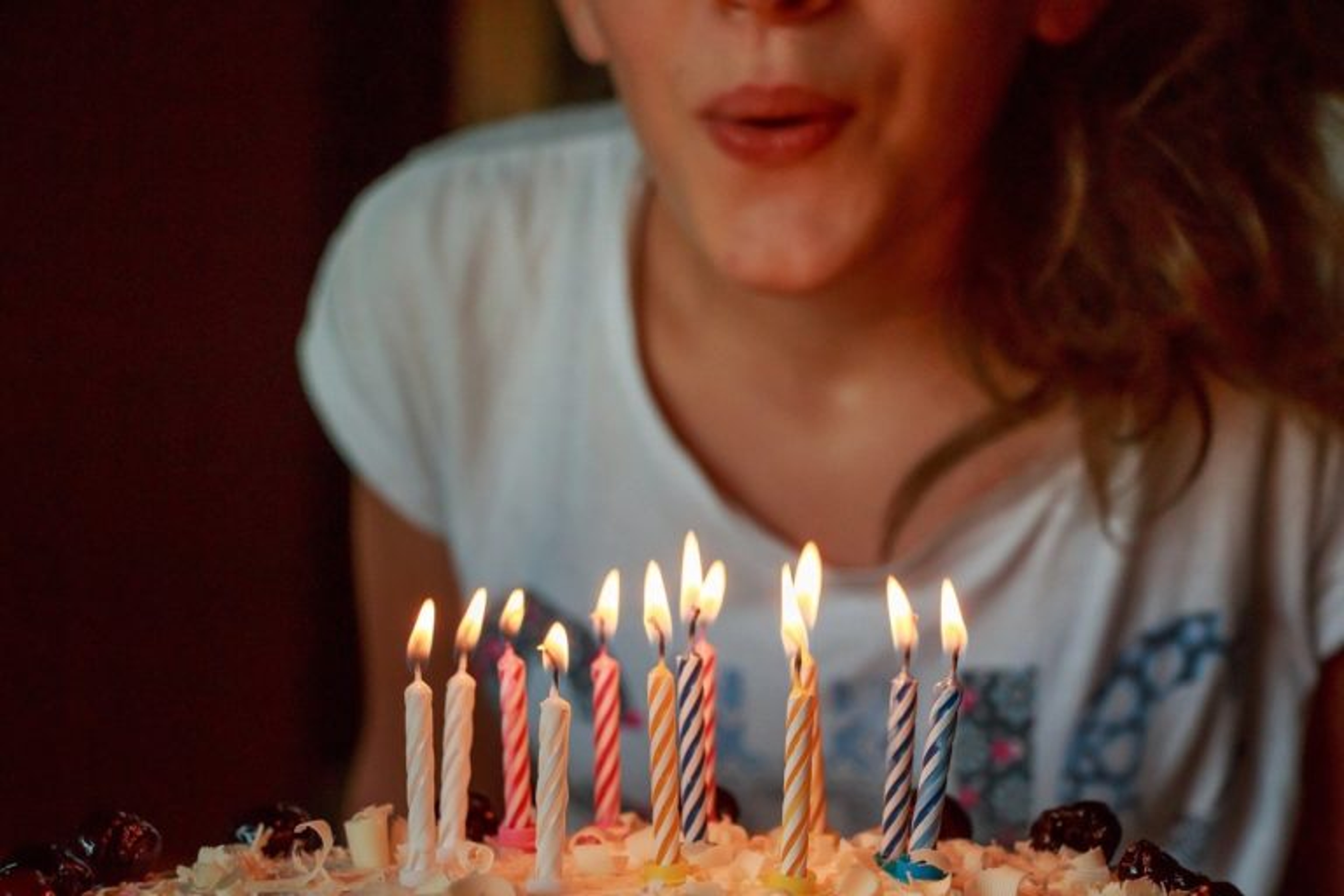 Woman blowing out birthday candles.