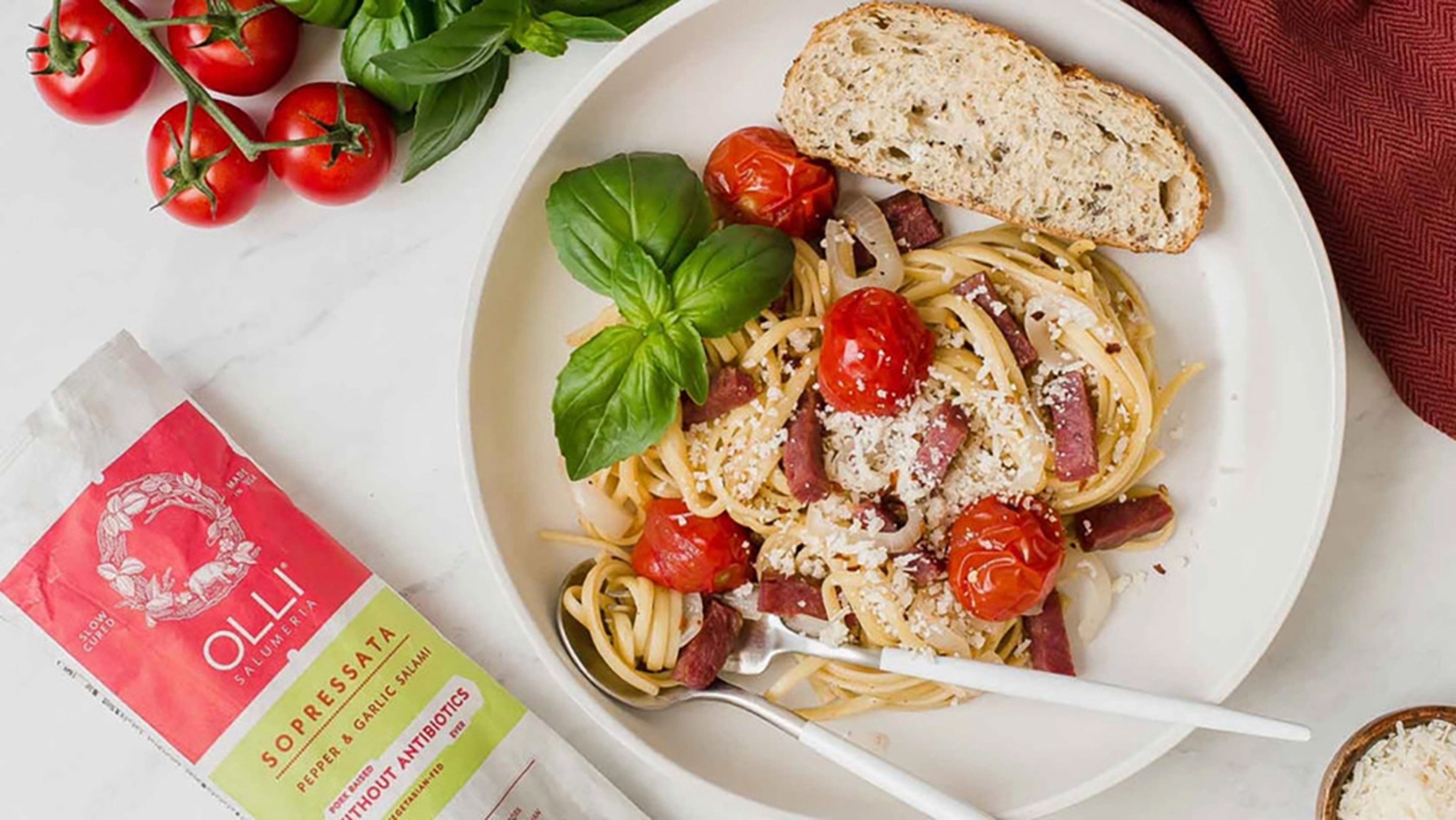 Plate of spaghetti with tomatoes and salami