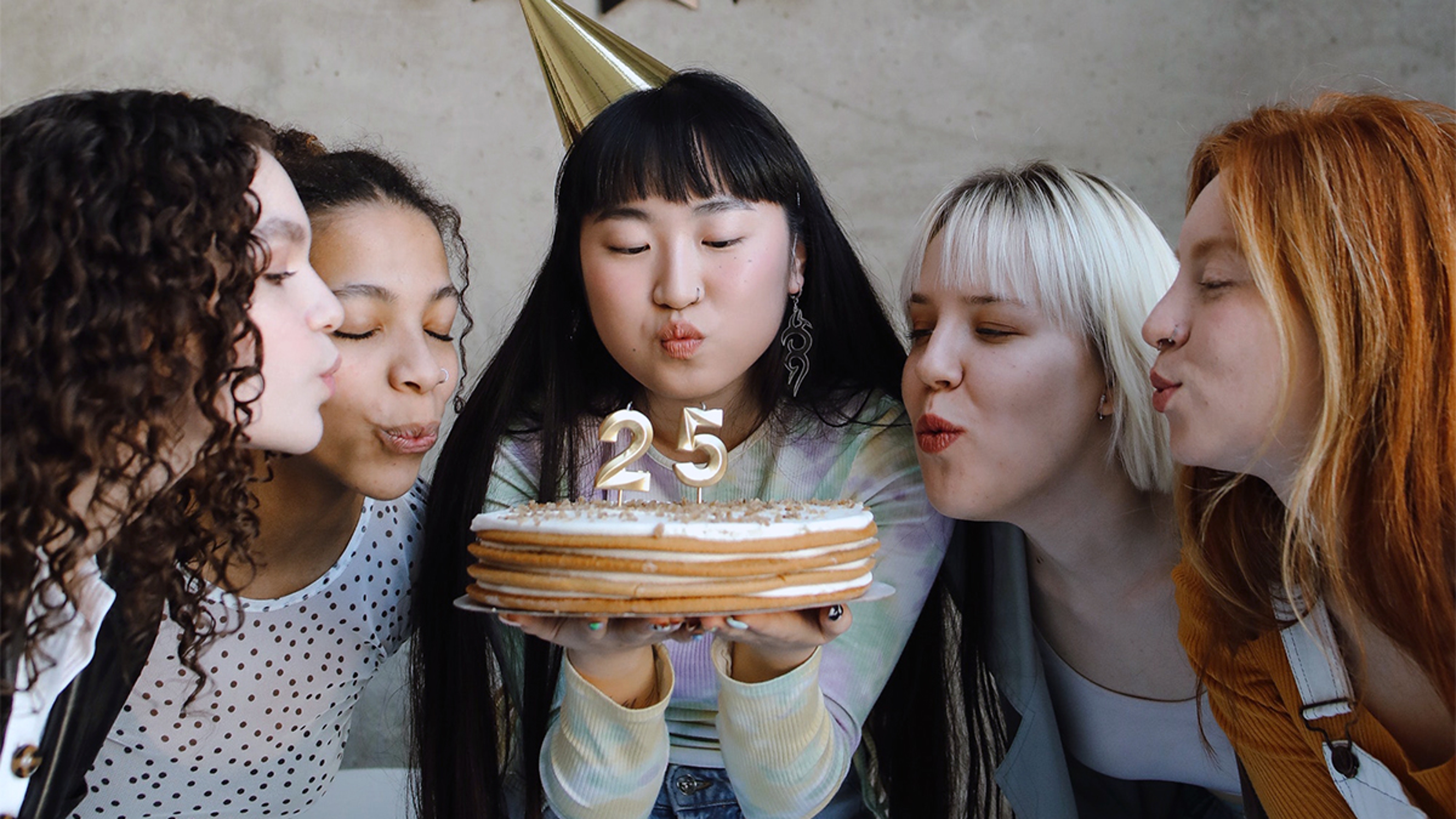 Article Cards Featured Image Group of women celebrating a milestone birthday and blowing out candles