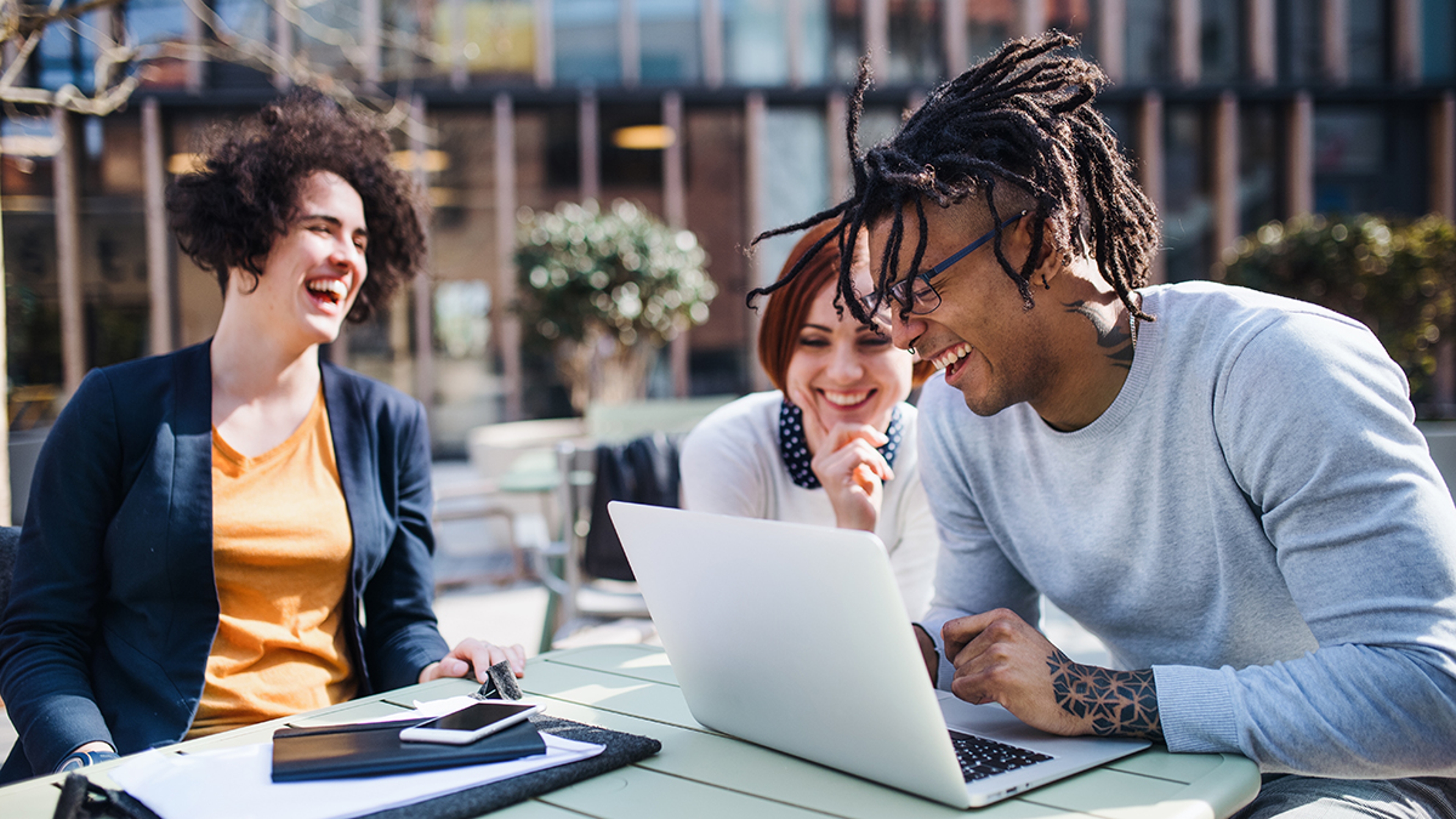 Article Cards Featured Image A group of young businesspeople using laptop in courtyard, start up concept.