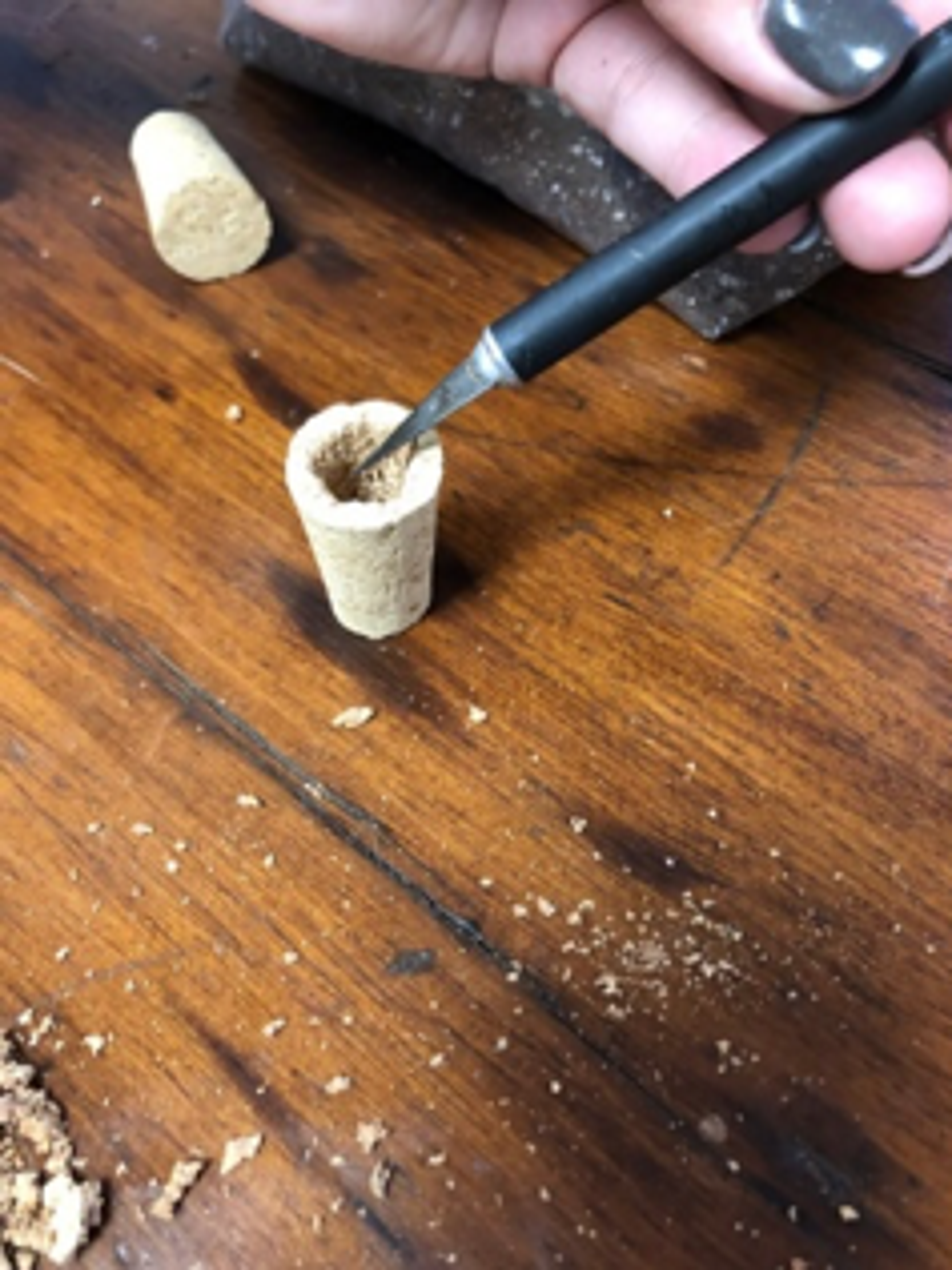 Hallow out the core of the cork with a knife