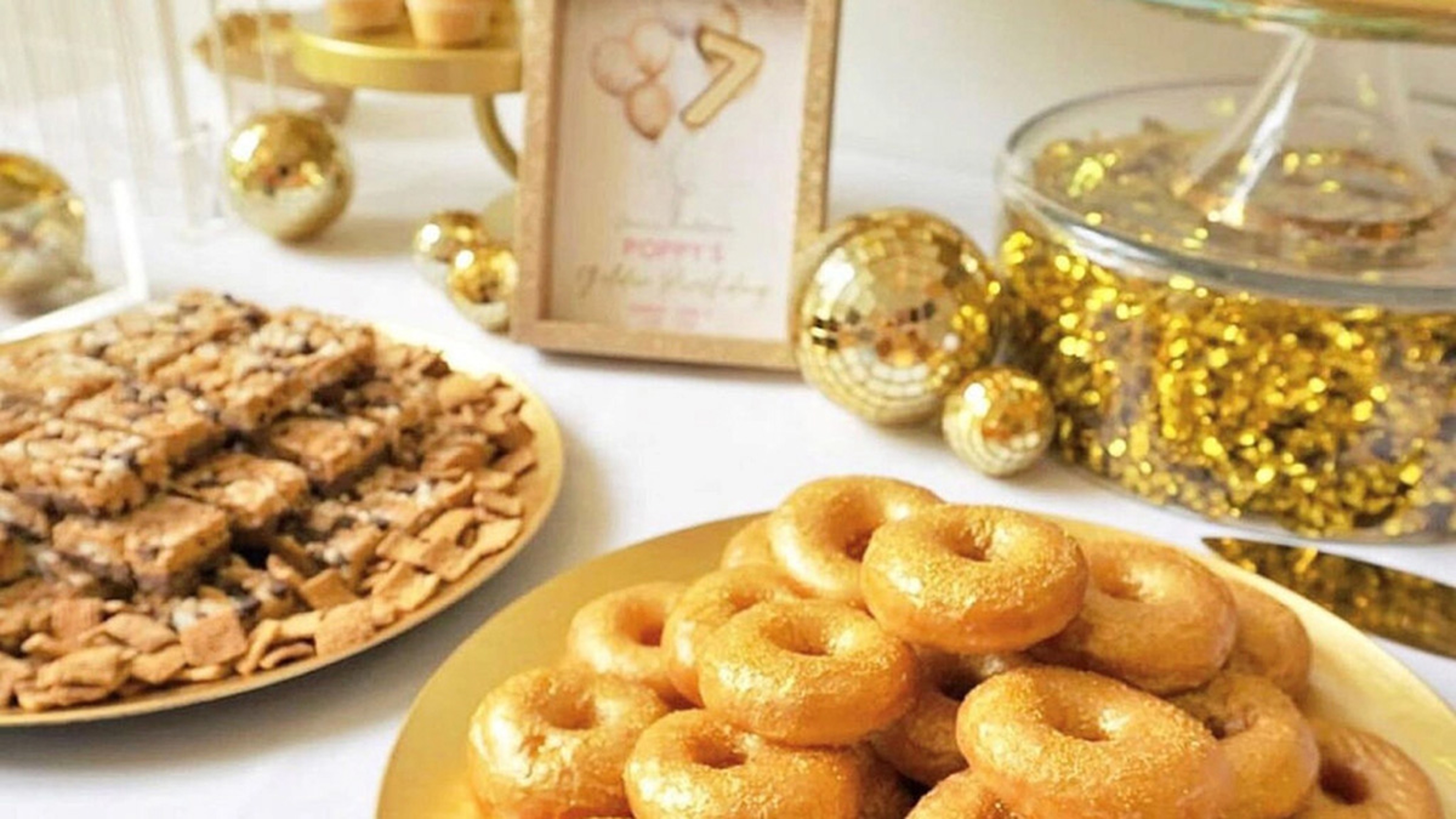 Table of desserts for golden birthday party.