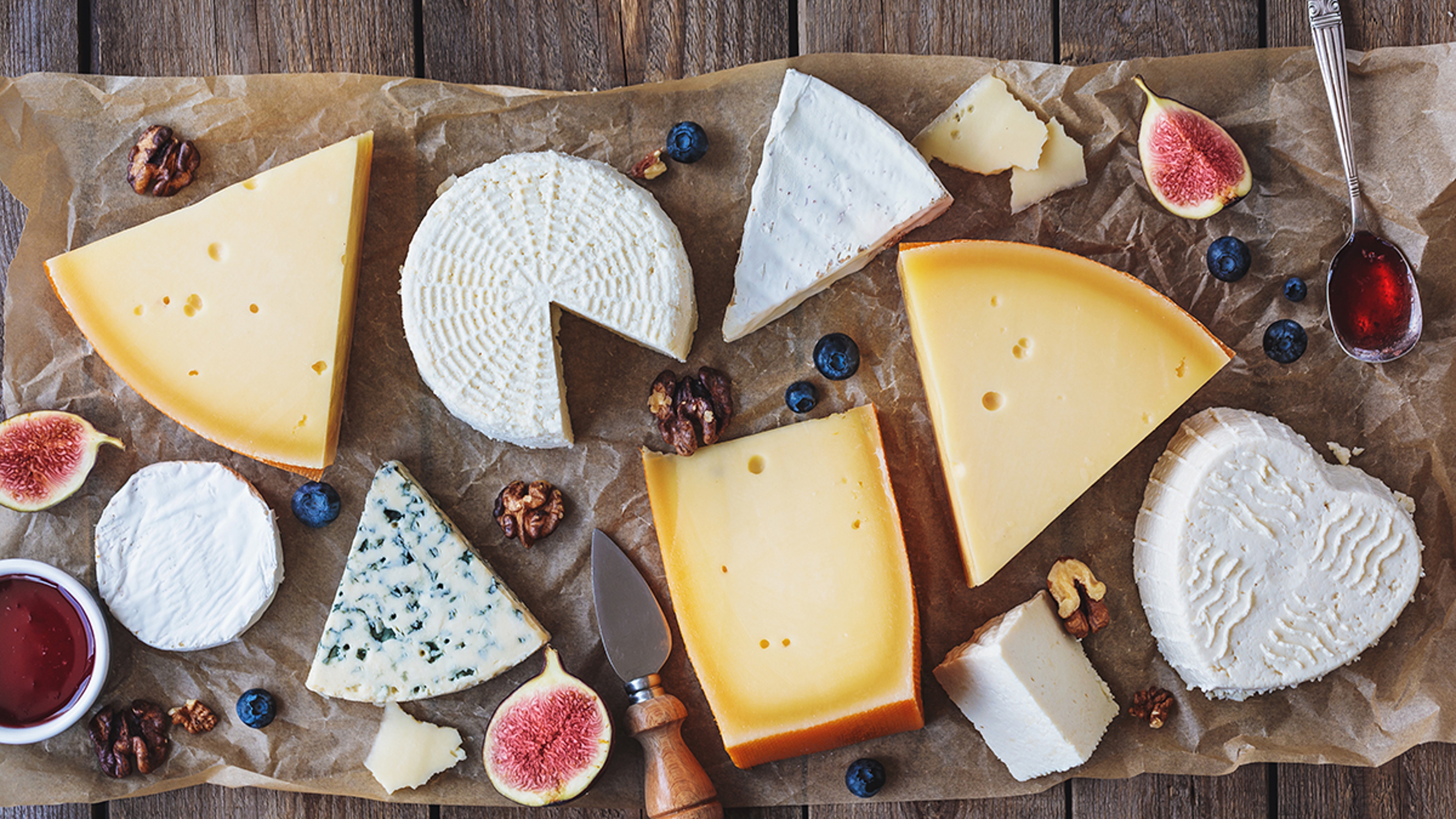various types of cheese on a rustic table top