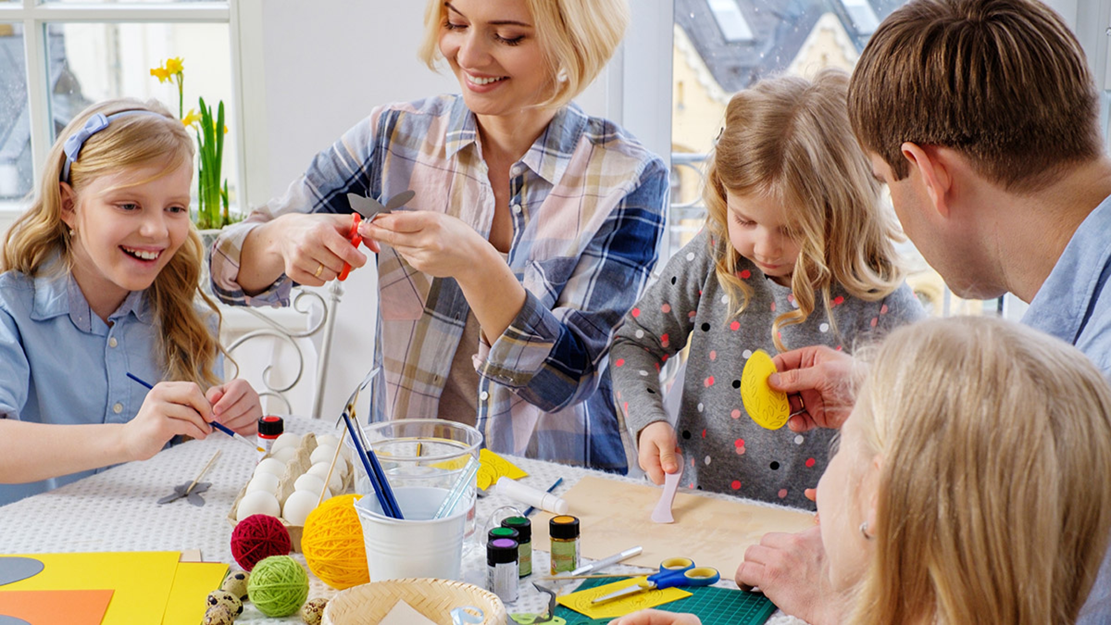 Article Cards Featured Image Cheerful family having fun painting and decorating easter eggs.