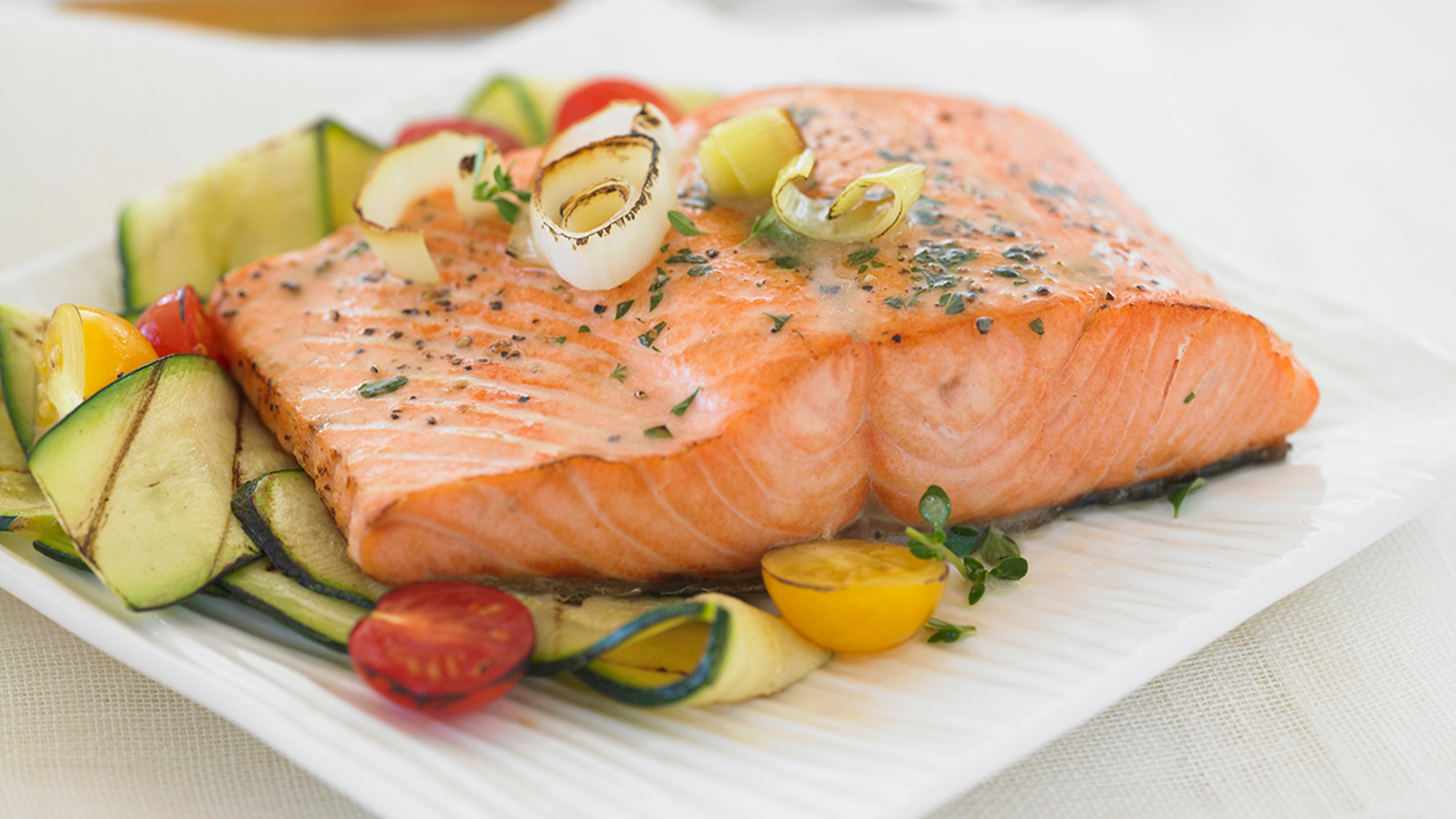 Alaskan silver salmon on a plate with vegetables.