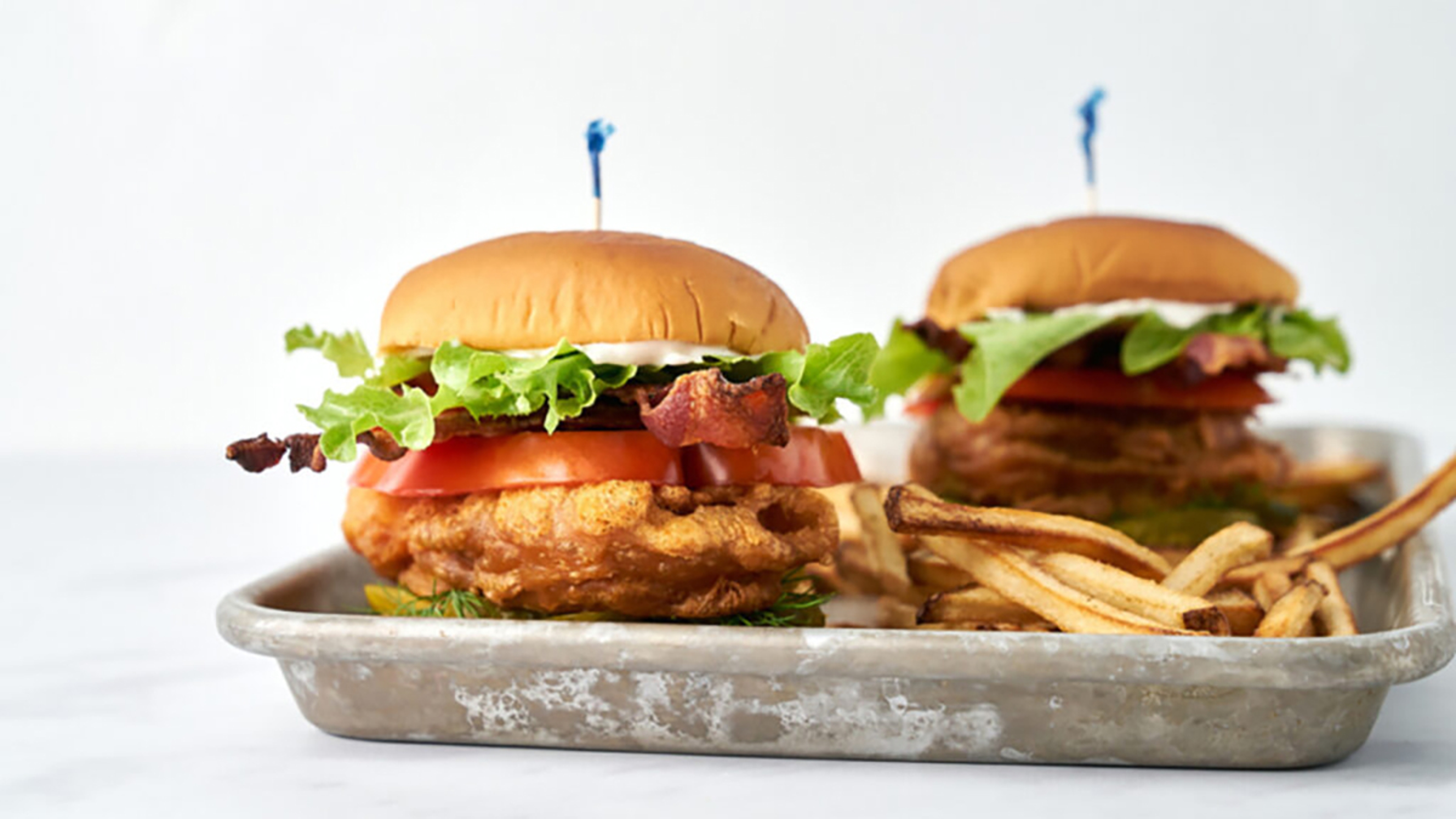 School lunches with a tray of blt cod sandwiches.