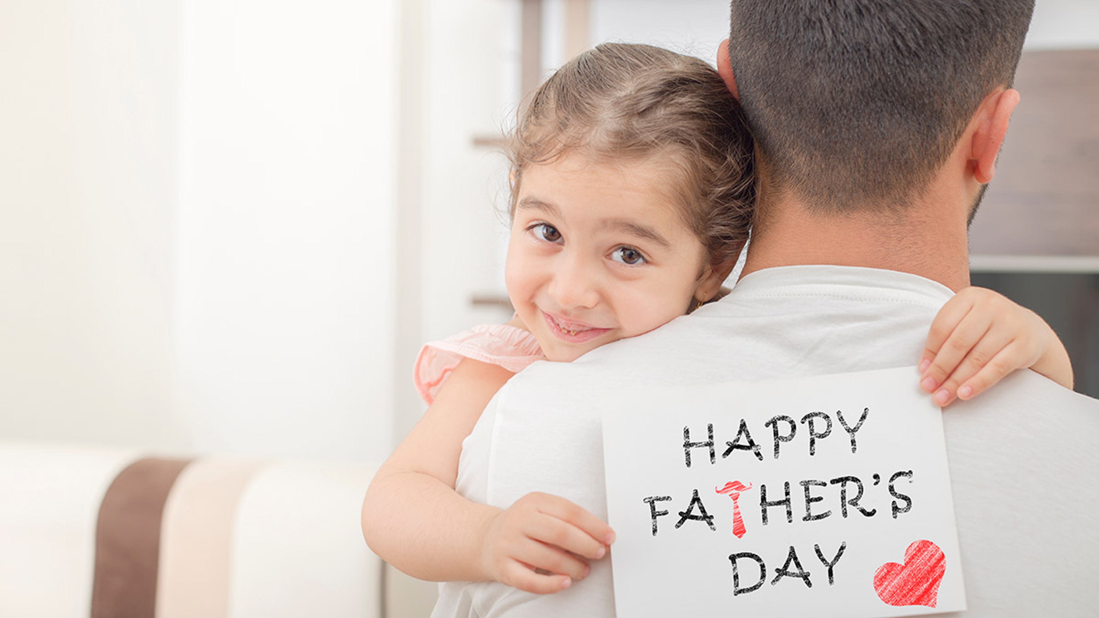 Article Cards Featured Image little girl hugs his father and shows happy fathers day card