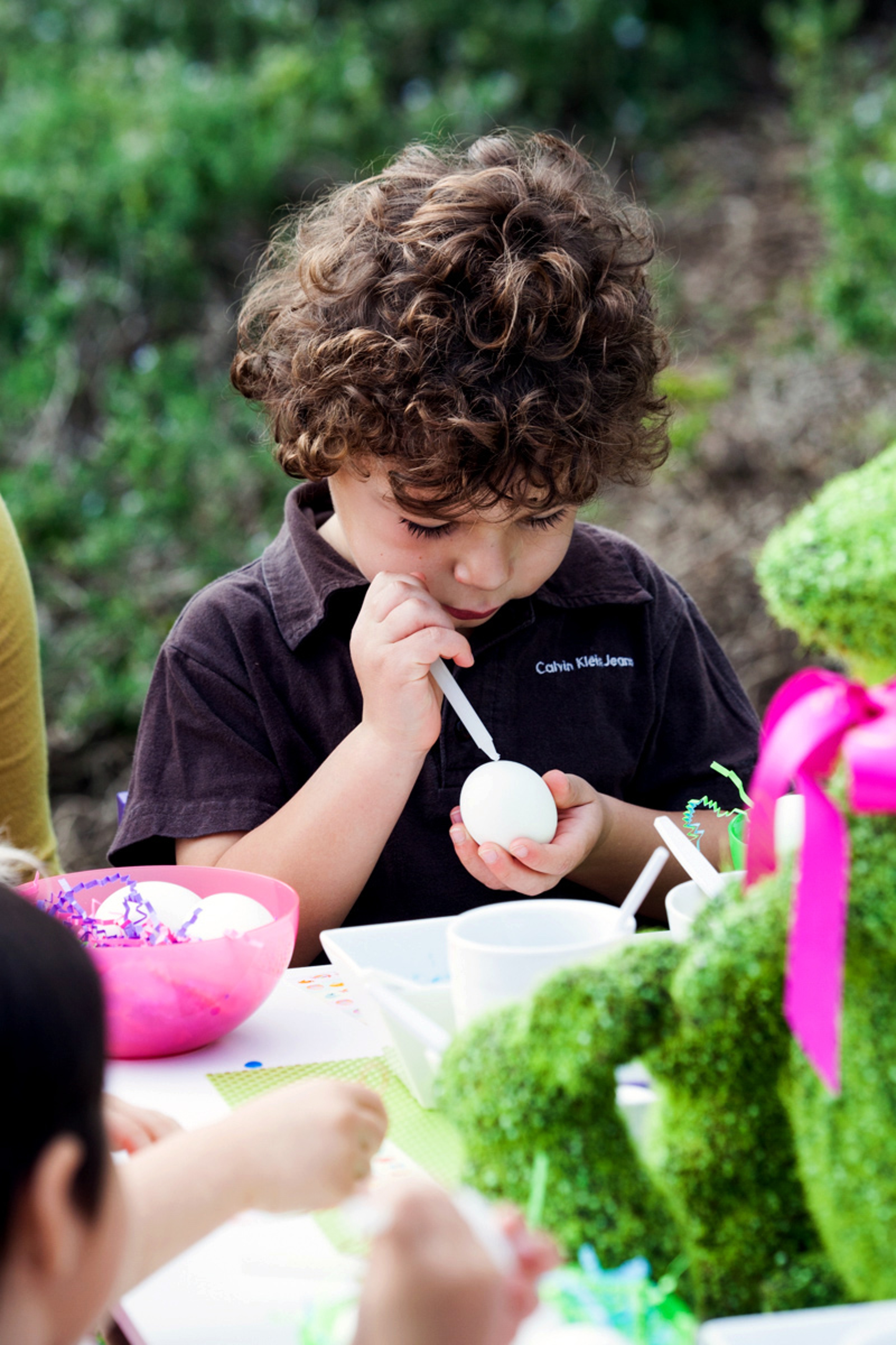 Easter Egg Decorating Party Kid drawing on egg before dying to make unique pattern