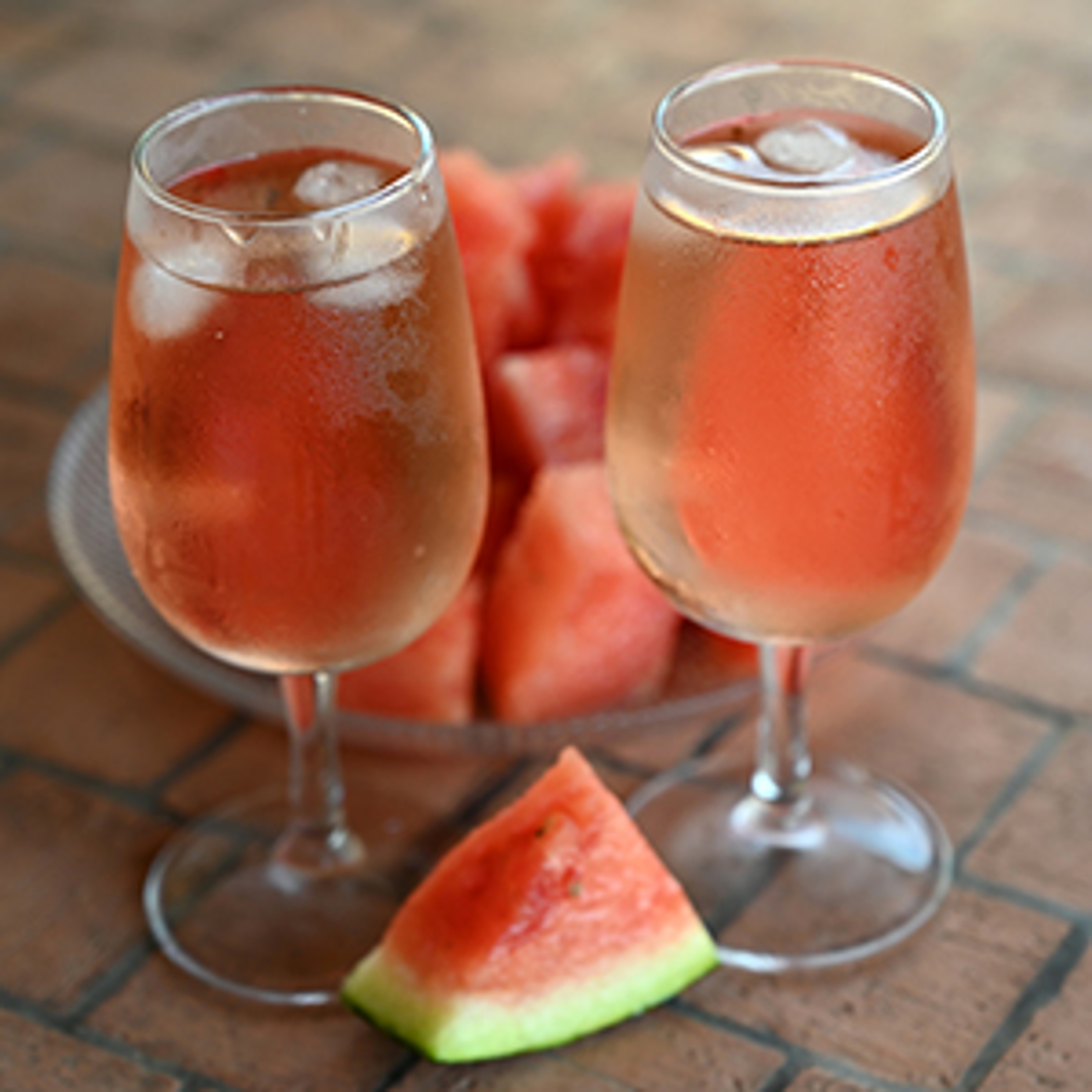 Verres de rosé avec des glaçons à côté d'un morceau de pastèque