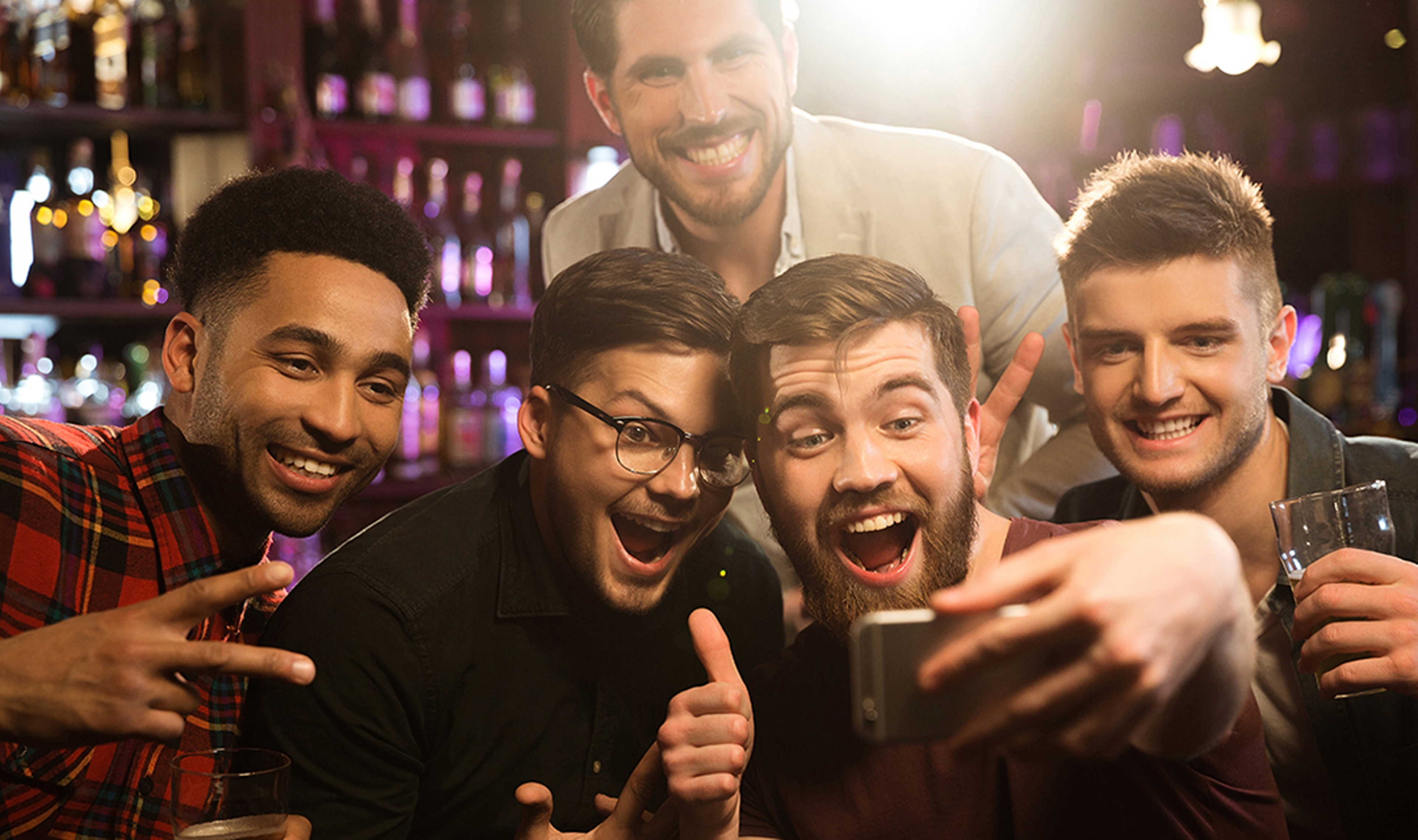 Happy male friends taking selfie and drinking beer at bar or pub